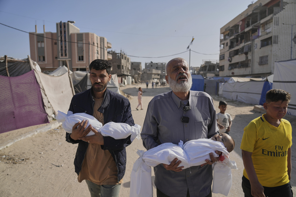 Abdel Rahman Sinwar, left, carries the body of his infant son, Yahia Sinwar, while the child's grandfather carries the body of his one-year-old grandson, Seif Sinwar