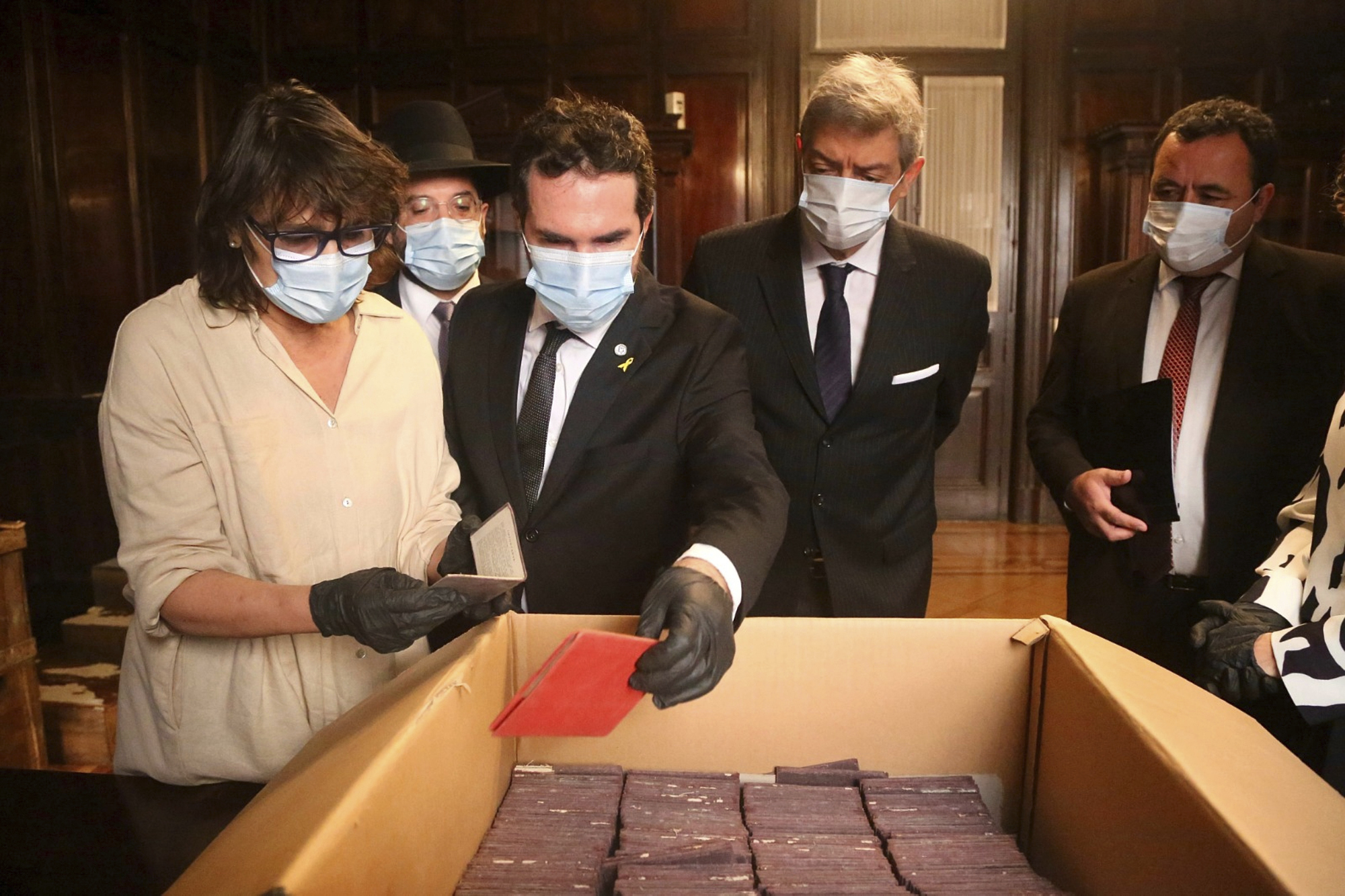 Officials inspect documents in a box.