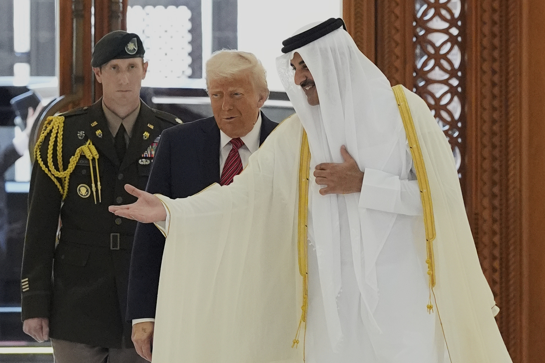 Emir Sheikh Tamim bin Hamad Al Thani gestures as he greets Donald Trump