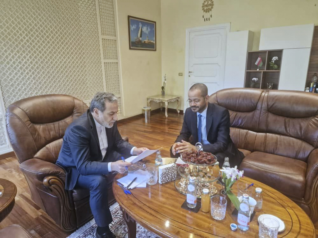 The foreign ministers of Oman and Iran sit with each other during negotiations