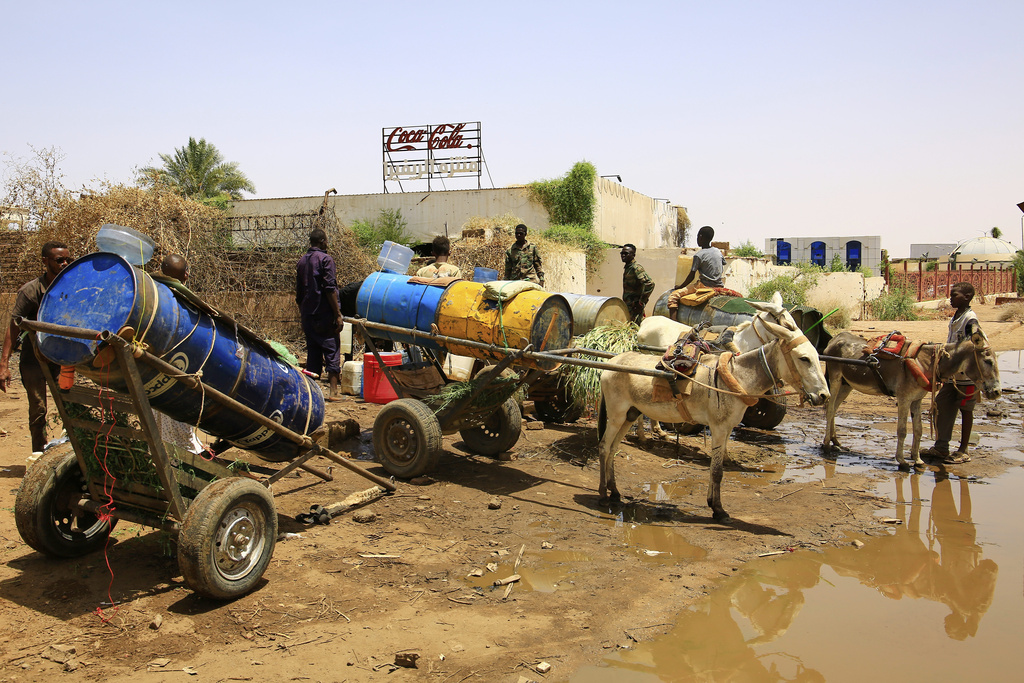 People fill water containers at a distribution point due to water outages in Khartoum