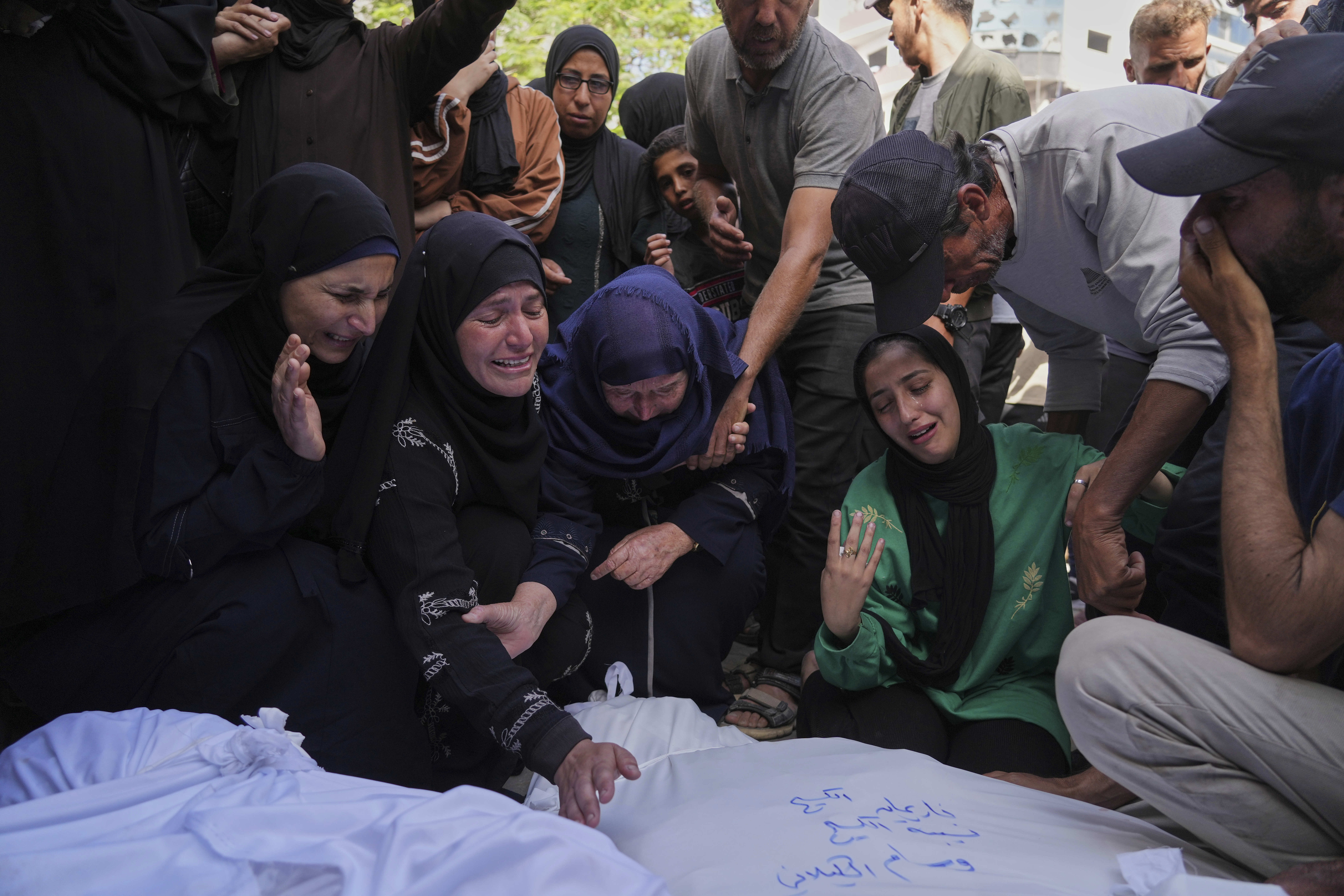 Walaa Al-Kilani mourns with other relatives over the bodies of her mother and brother, who were killed when an Israeli military strike hit a school sheltering displaced residents, at Al-Shifa Hospital in Gaza City, Monday, May 26, 2025.