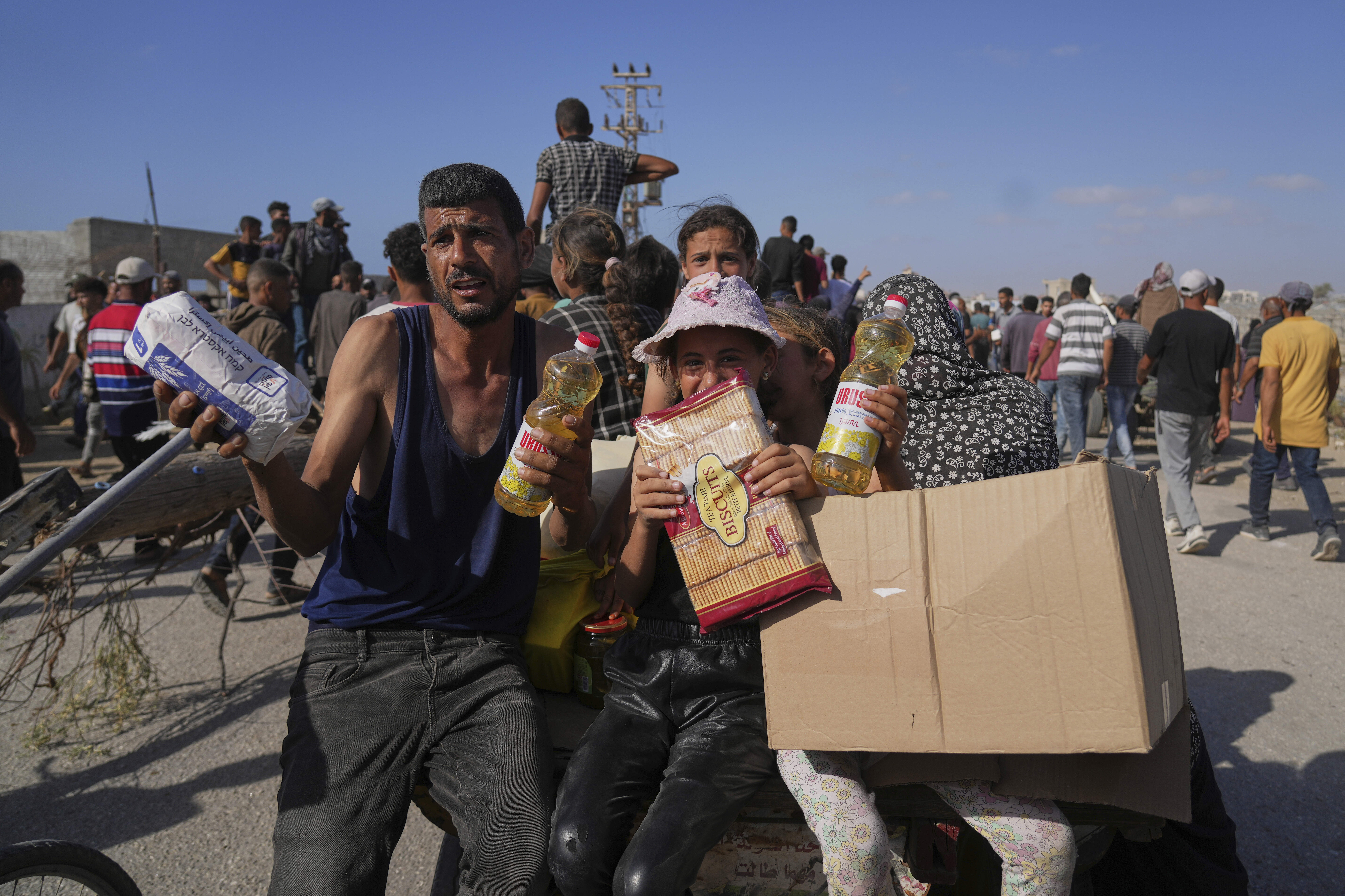 Palestinians show to the camera food and humanitarian aid packages they received from the Gaza Humanitarian Foundation.
