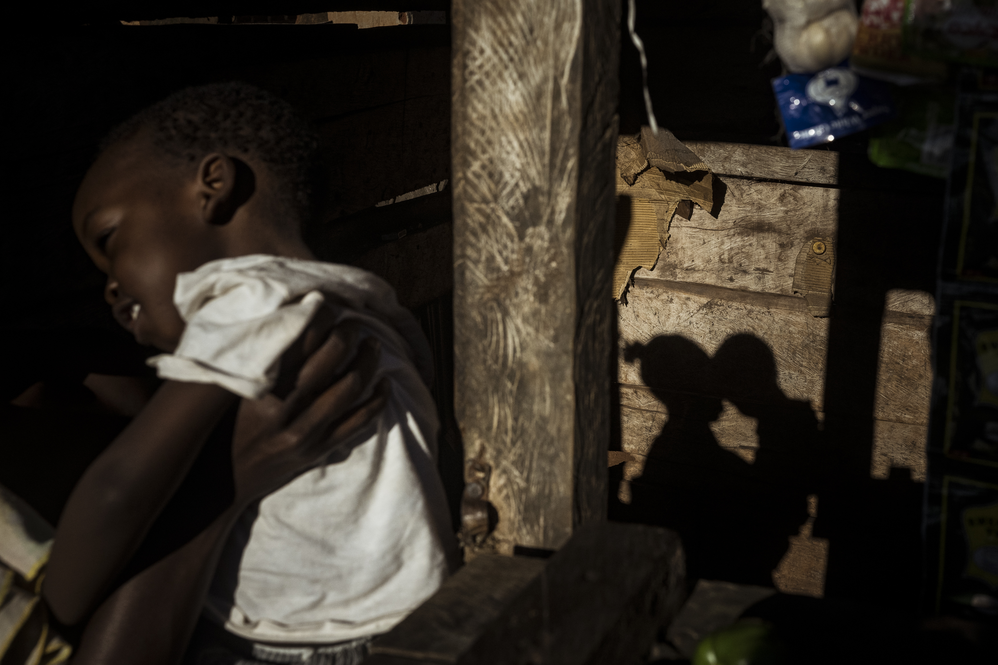 Wanyange, Uganda. Margret Nakimbugwe shares a loving embrace with her two-year-old son Ali Nsimba at the roadside stall she operates. Ali lives with Cerebral Palsy and receives his weekly therapy at the Home of Hope facility in nearby Jinja. As a mother of a child living with disability Margret receives counselling from the social workers at Home of Hope, a local facility proving assistance to those living with disability. After vetting, she was given some interest free start-up capital from which Margret has been able to start a small business selling charcoal at the local trading centre. Despite living subsistently now, Margret is confident she can expand her business and provide for Ali's future needs. [Christopher Hopkins/Al Jazeera]