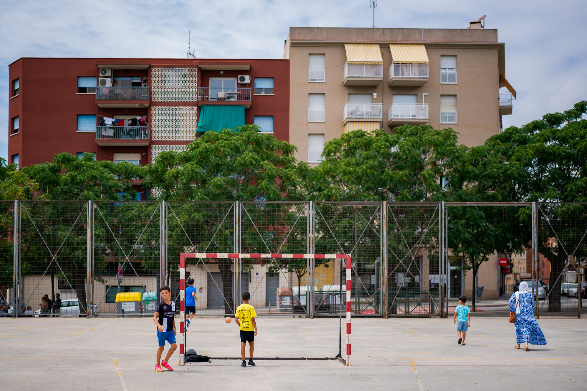 Kids play football in the park.