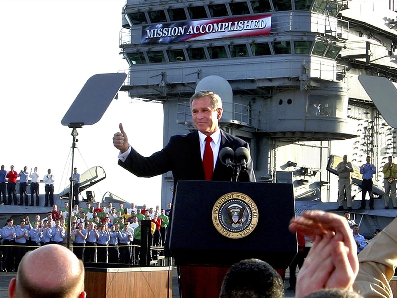 George W. Bush, as US President, gives thumbs up as he declares end of major combat in Iraq aboard aircraft carrier USS Abraham Lincoln, off California coast, photo
