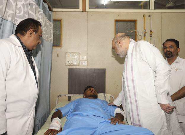 This handout photo issued by the Indian Ministry of Home Affairs shows Home Affairs Minister Amit Shah meeting British plane crash survivor Vishwash Kumar Ramesh,