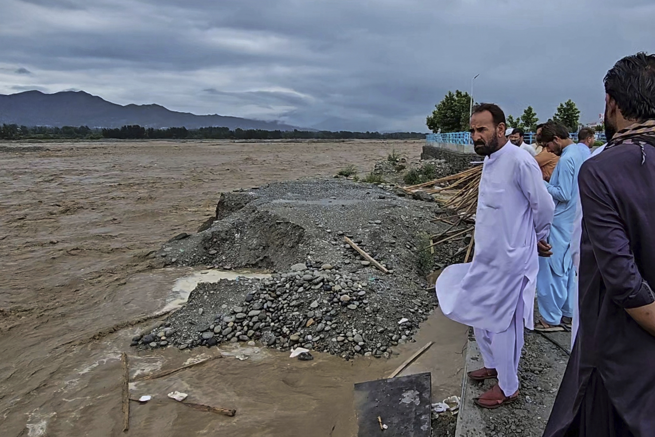Local residents look to the Swat River, which is overflowing due to pre-monsoon heavy rains in the area, on the outskirts of Mingora, the main town of Pakistan's Swat Valley, Friday, June 27, 2025. (AP Photo/Sherin Zada)
