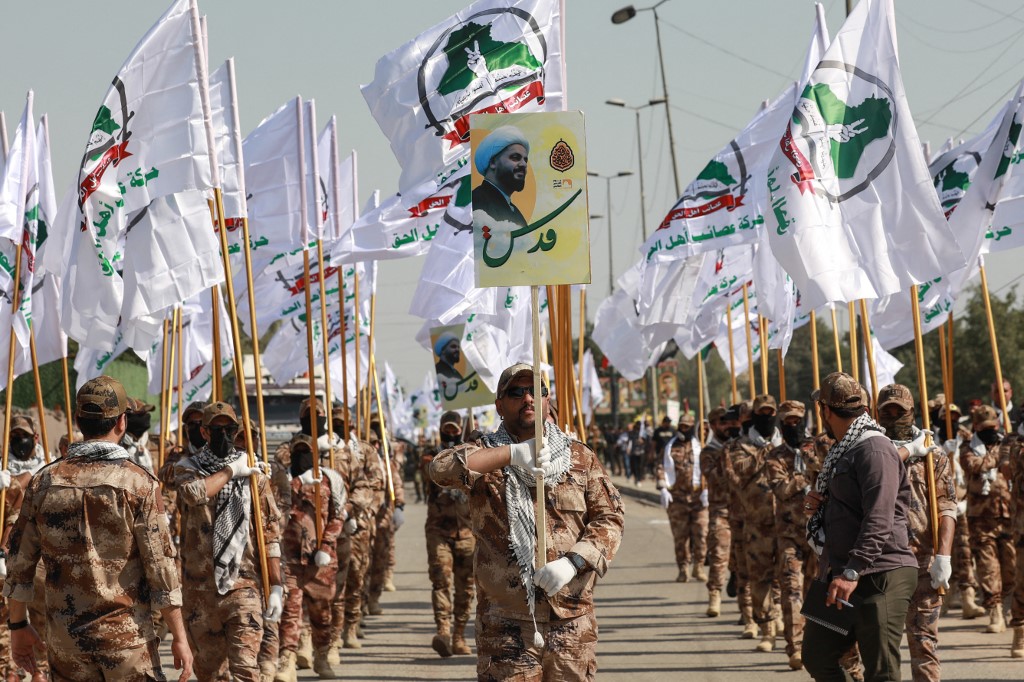 Fighters from Iraq's Hashed al-Shaabi (Popular Mobilisation Forces) carry flags as they rally to mark the annual Jerusalem day commemorations in Baghdad on March 28, 2025. [Murtaja Lateef/ AFP]