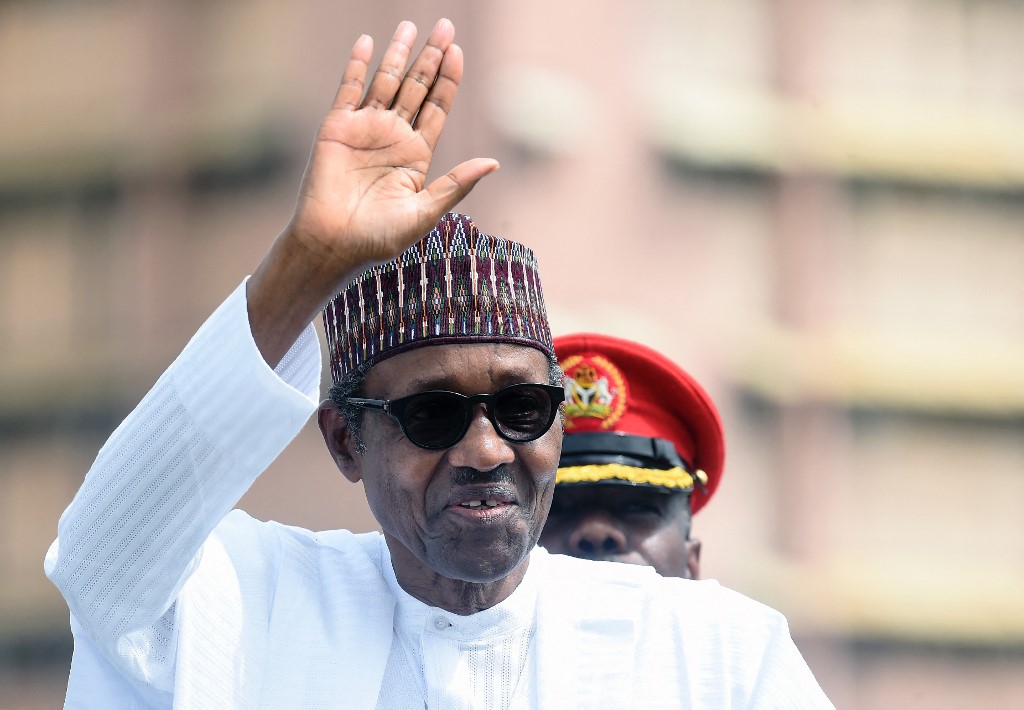 Former Nigerian President Muhammadu Buhari salutes during an inspection of guards on parade to mark Democracy Day in Abuja, on June 12, 2019. [File: Pius Utomi Ekpei/AFP]