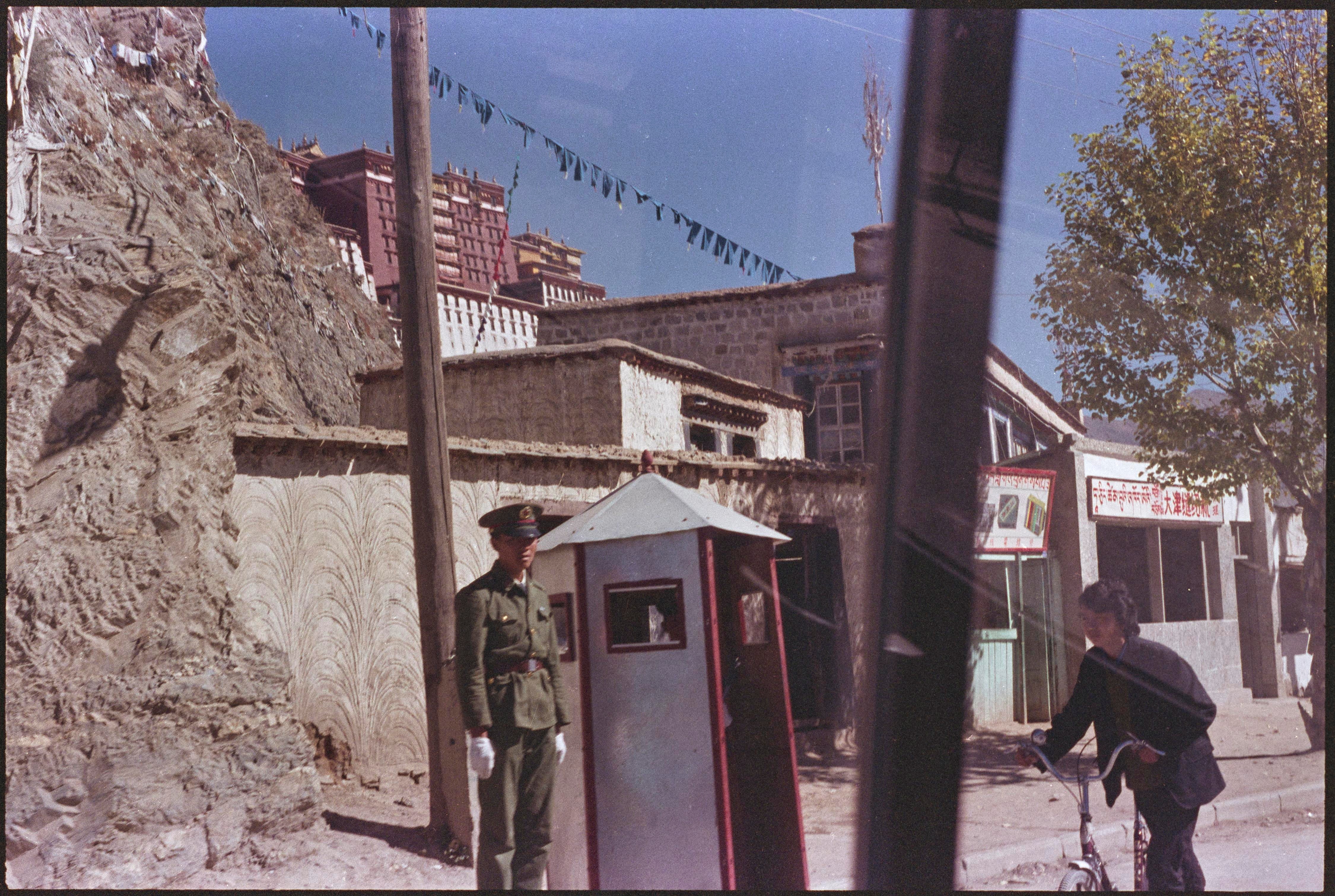 Chinese soldier mans checkpoint on Lhasa street. Former residence of Dalai Lama, the Potala Palace in background. October 24, 1989 REUTERS/Guy Dinmore