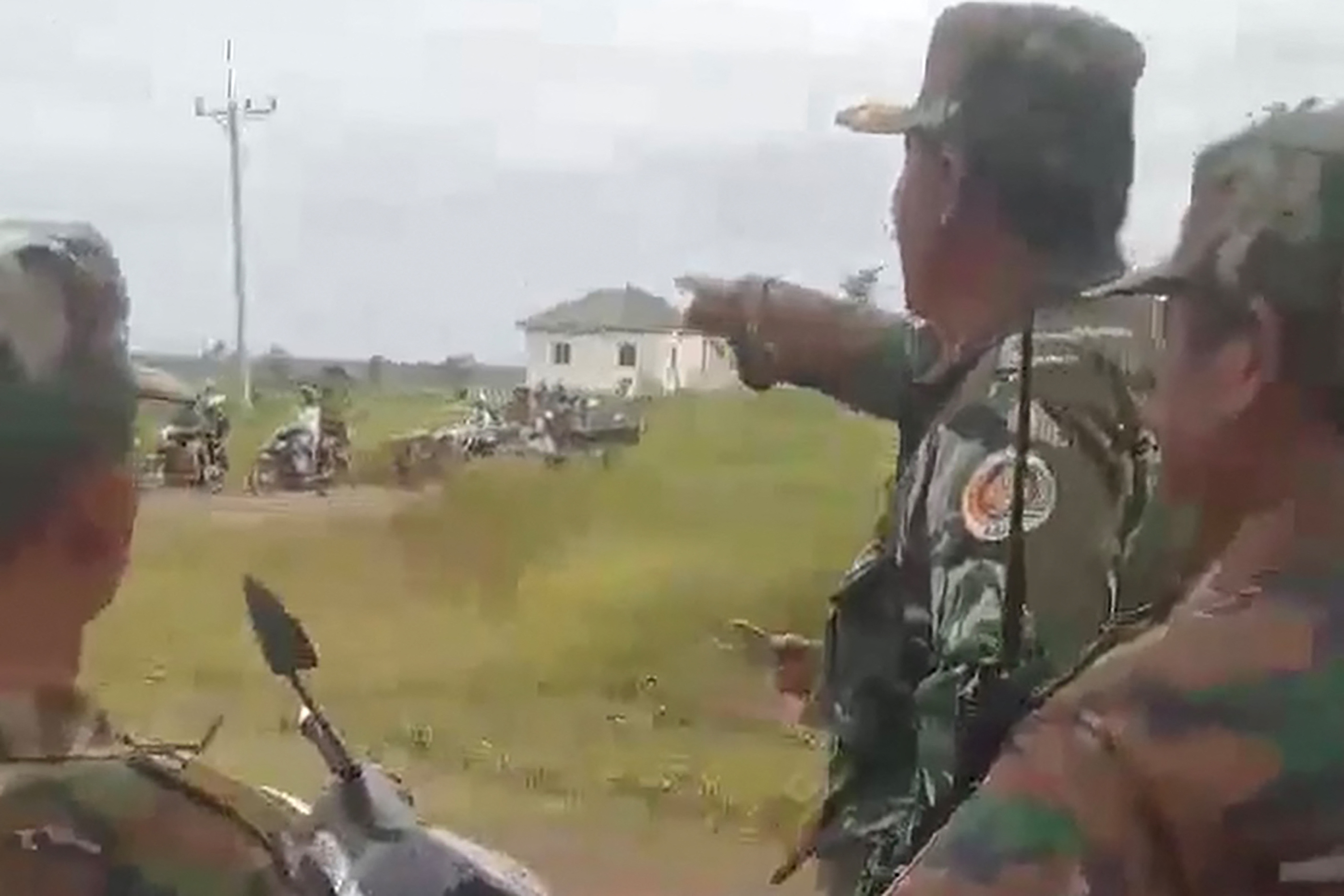 Cambodian soldiers look at people evacuate from along the Cambodia-Thailand border