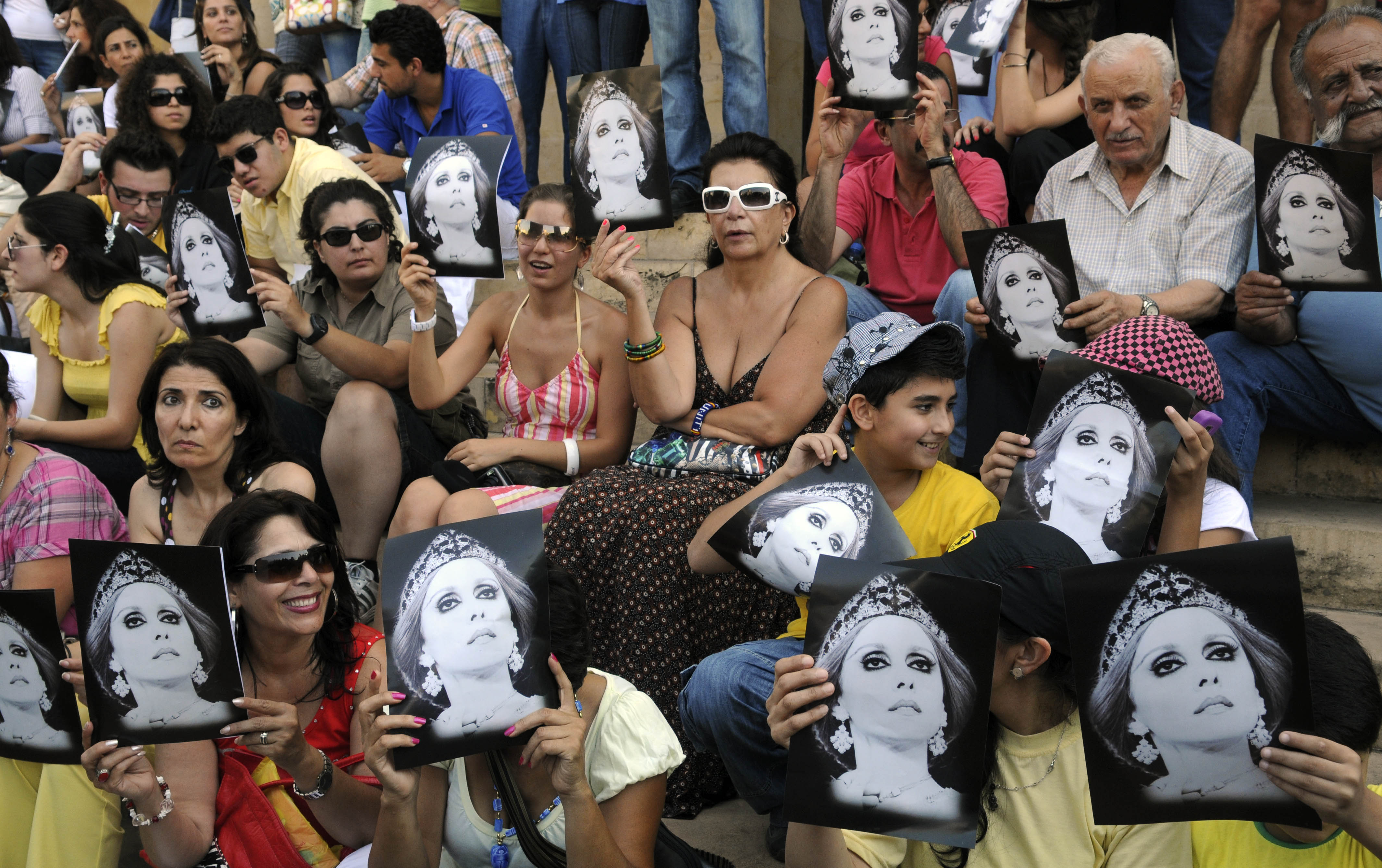 In this photo taken Monday, July 26, 2010, fans of Lebanese diva Fairouz hold her pictures as they protest against a ban preventing her from performing songs composed by "The Rahbani Brothers," as family heirs fight over inheritance and property rights, in Beirut, Lebanon. For four decades, Lebanese singer Fairouz has performed on the world's most prestigious stages, moving audiences to tears with songs of freedom, justice and love throughout 15-years of civil war. Now, a bitter family dispute over inheritance, song royalties and intellectual property rights is threatening to silence Lebanon's most beloved diva, who is now 75-years old, and fans are outraged, and marching in the streets to ask her to keep singing. (AP Photo/Ahmad Oma