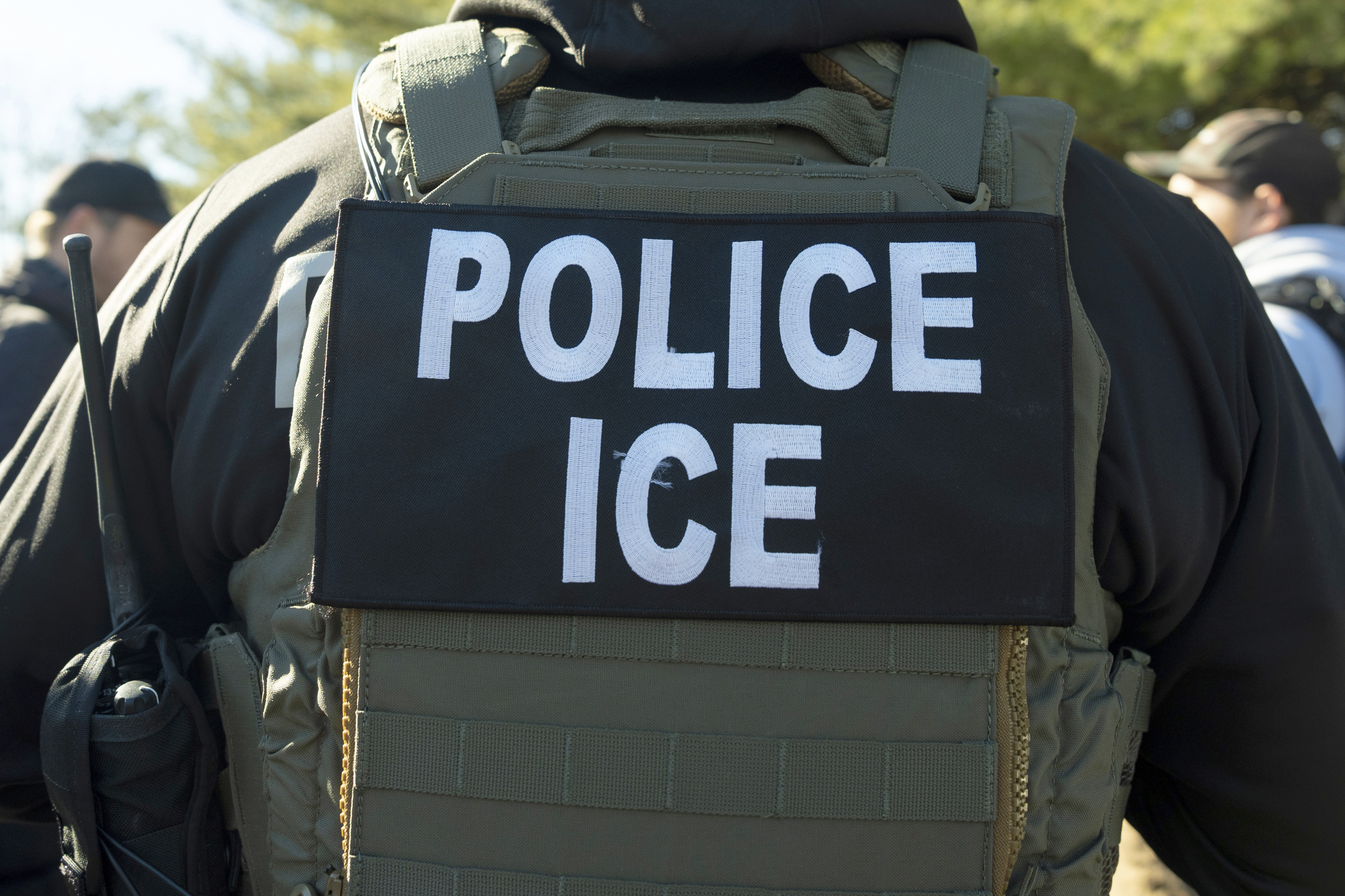 A close-up of a bullet-proof vest that reads, "Police ICE"