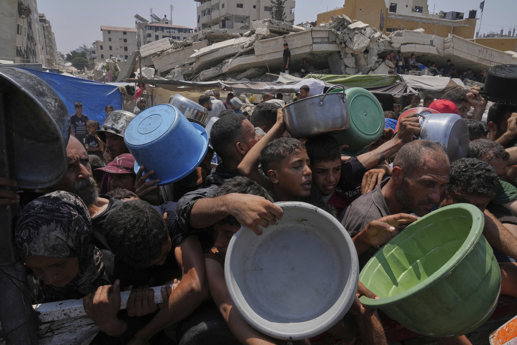 Palestinians struggle to get donated food at a community kitchen, in Gaza City, northern Gaza Strip, Saturday, July 26, 2025 [Abdel Kareem Hana/AP Photo]