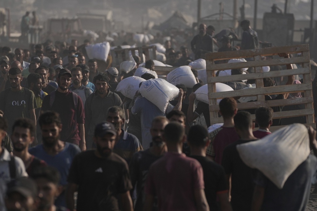 People walk with bags of flour