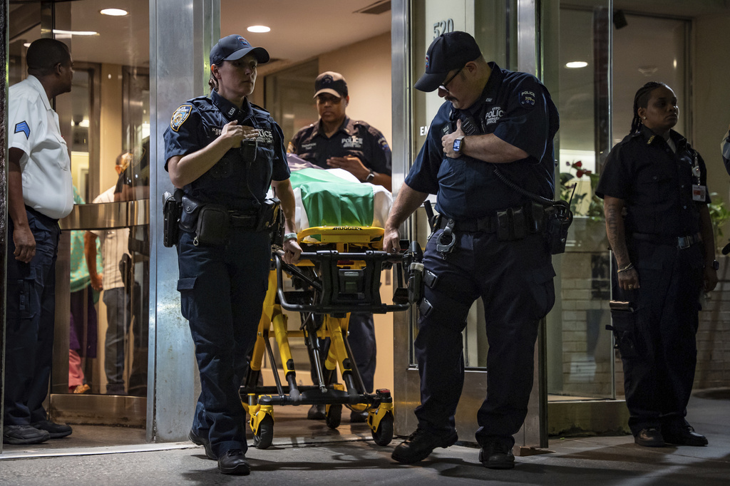 the body of a person slain in a shooting is transported out of a building