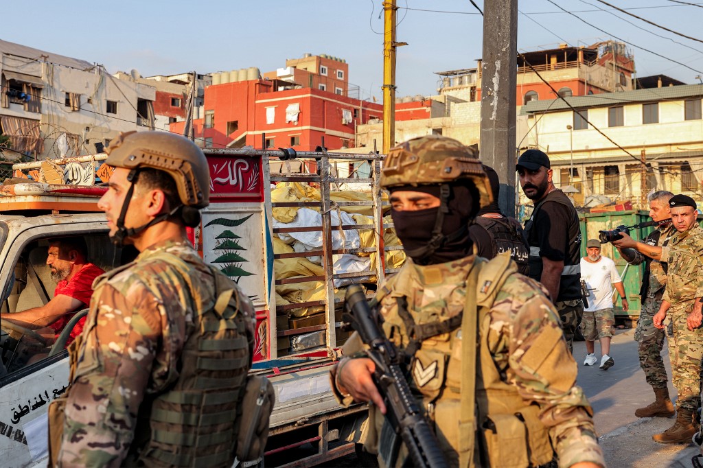 Lebanese army and security forces gather near a pickup truck carrying a cache of small arms exiting the Burj al-Barajneh camp for Palestinian refugees in Beirut's southern suburbs on August 21, 2025 [Anwar Amro/AFP]