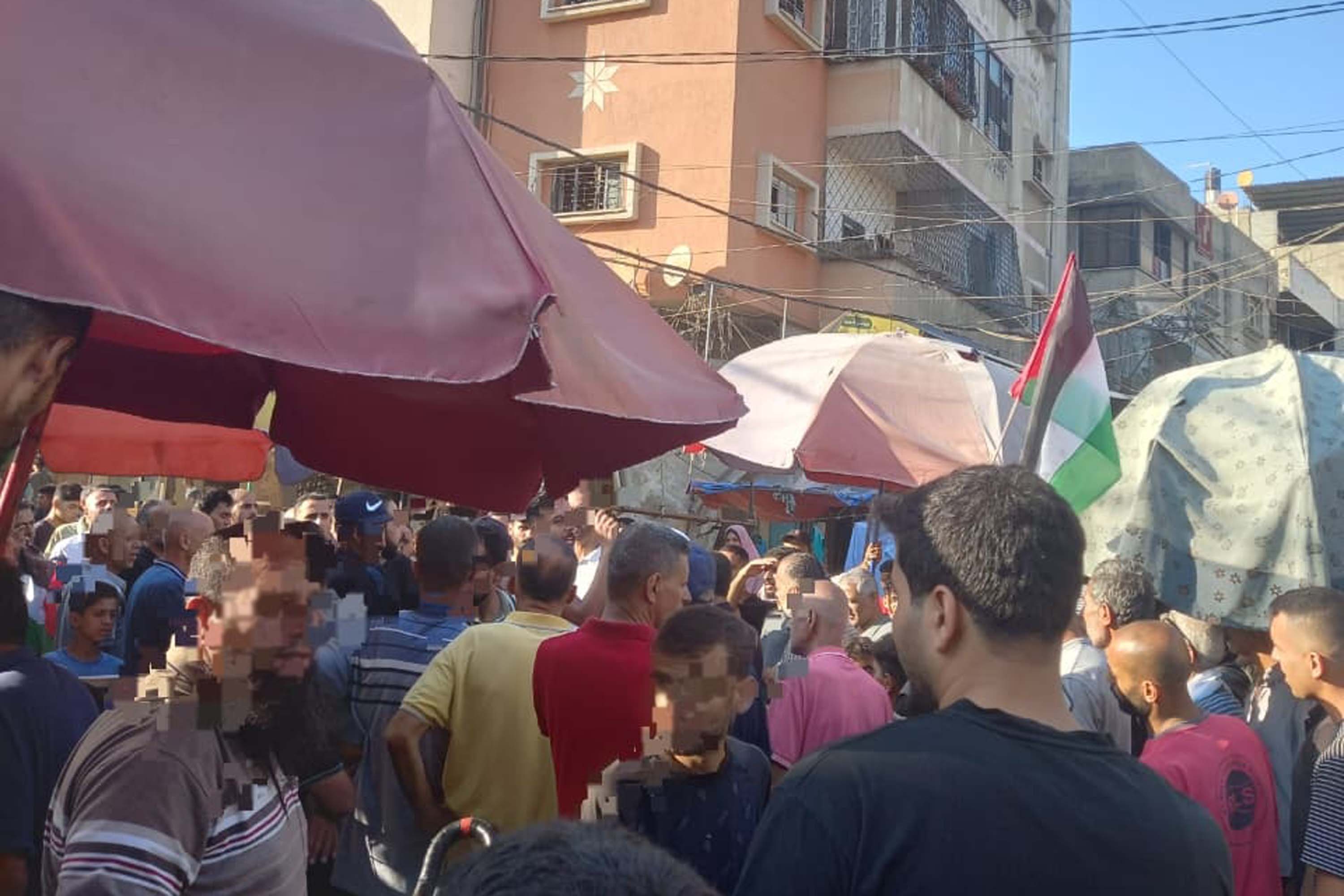 A crowd gathers at a market in Nuseirat camp to protest price speculation on August 2, 2025 [Courtesy of Amal Abu Saif]