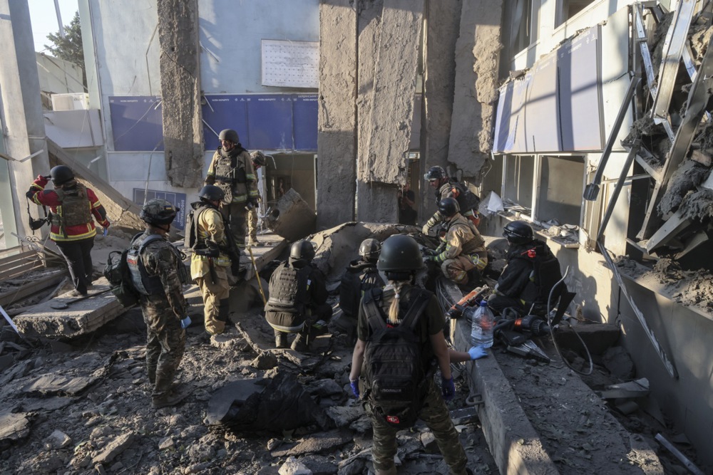 people wearing uniforms stand inside a bombed out building