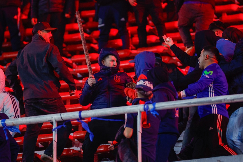 Universidad de Chile fans clash in the stands during the CONMEBOL Copa Sudamericana round of 16 soccer match between Independiente and Universidad de Chile