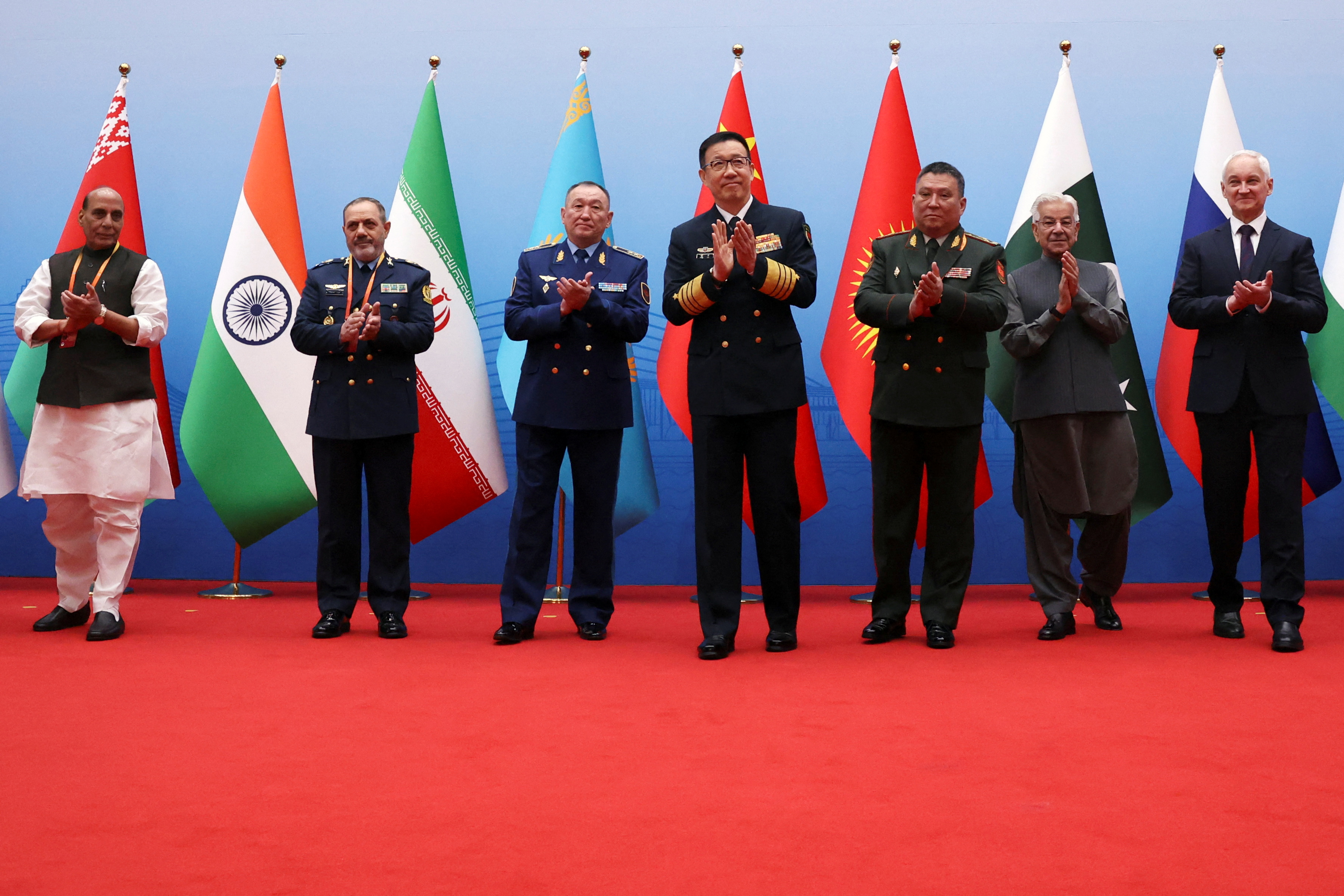 Chinese Defence Minister Dong Jun, India's Defence Minister Rajnath Singh, Iran's Defence Minister Aziz Nasirzadeh, Kazakhstan's Defence Minister Dauren Kosanov, Kyrgyzstan's Defence Minister Ruslan Mukambetov, Pakistan's Defence Minister Khawaja Asif and Russia's Defence Minister Andrei Belousov applaud following a group photo, before the Shanghai Cooperation Organisation (SCO) Defence Ministers' Meeting in Qingdao, Shandong province, China June 26, 2025. REUTERS/Florence Lo