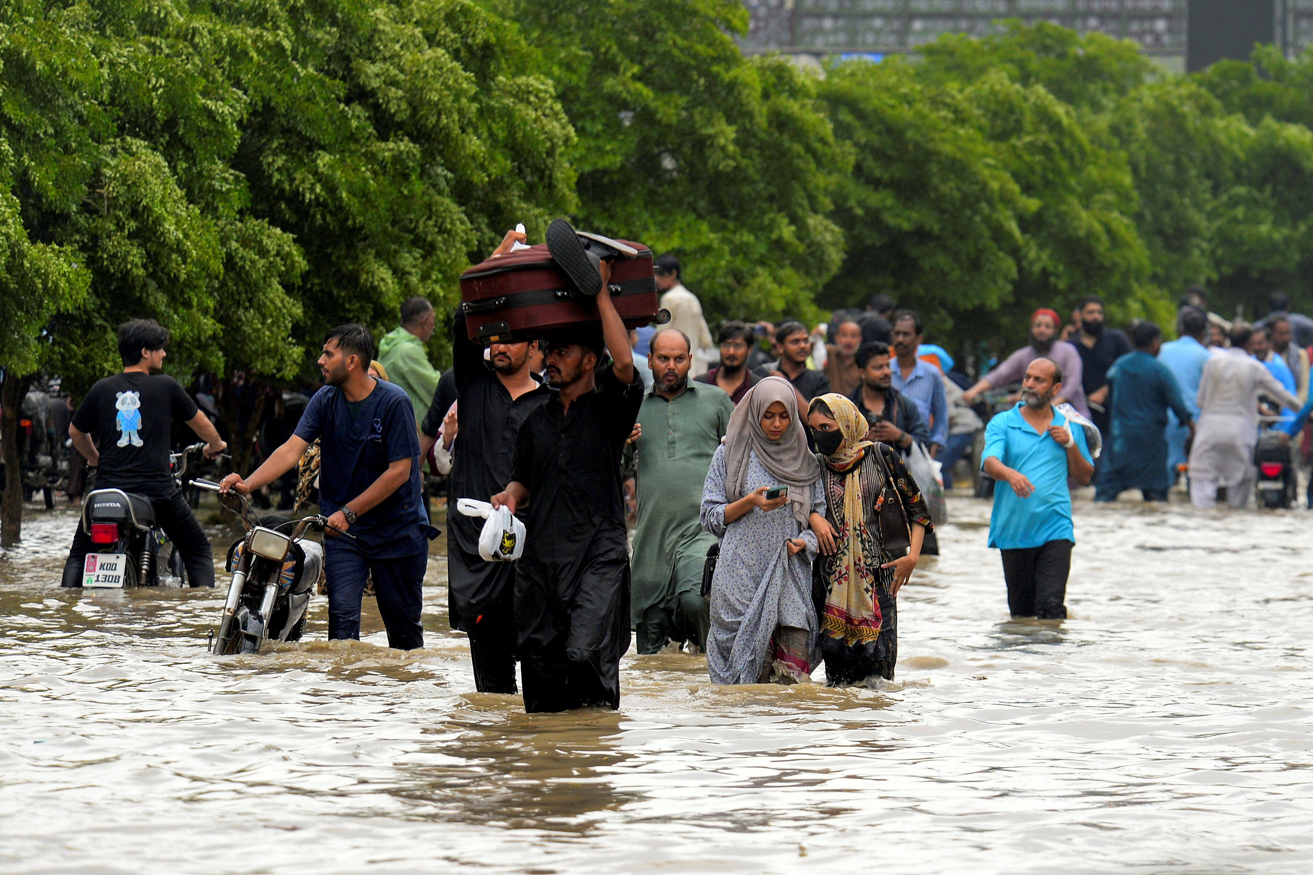 People wade through a flooded road after the monsoon rain in Karachi, Pakistan, August 19, 2025. [File: Imran Ali/Reuters]