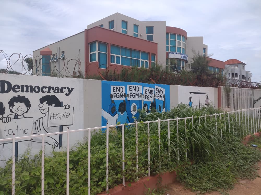A wall mural reads 'END FGM' in Banjul, Gambia