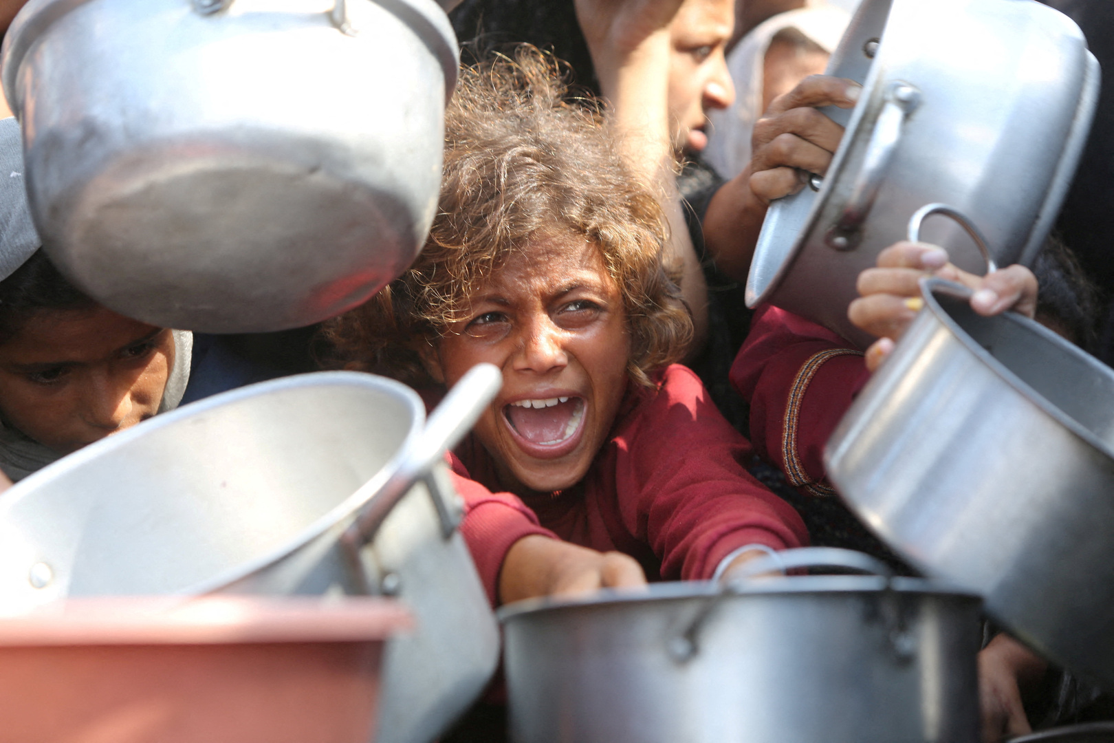 Palestinians shove to receive food portions from a charity kitchen in Khan Yunis in the southern Gaza Strip on Aug. 27, 2025. The UN officially declared a famine in Gaza on August 22, blaming the "systematic obstruction" of aid by Israel during more than 22 months of war. The Rome-based Integrated Food Security Phase Classification Initiative (IPC) said famine was affecting 500,000 people in Gaza governorate, which covers about a fifth of the Palestinian territory including Gaza City. [AFP]