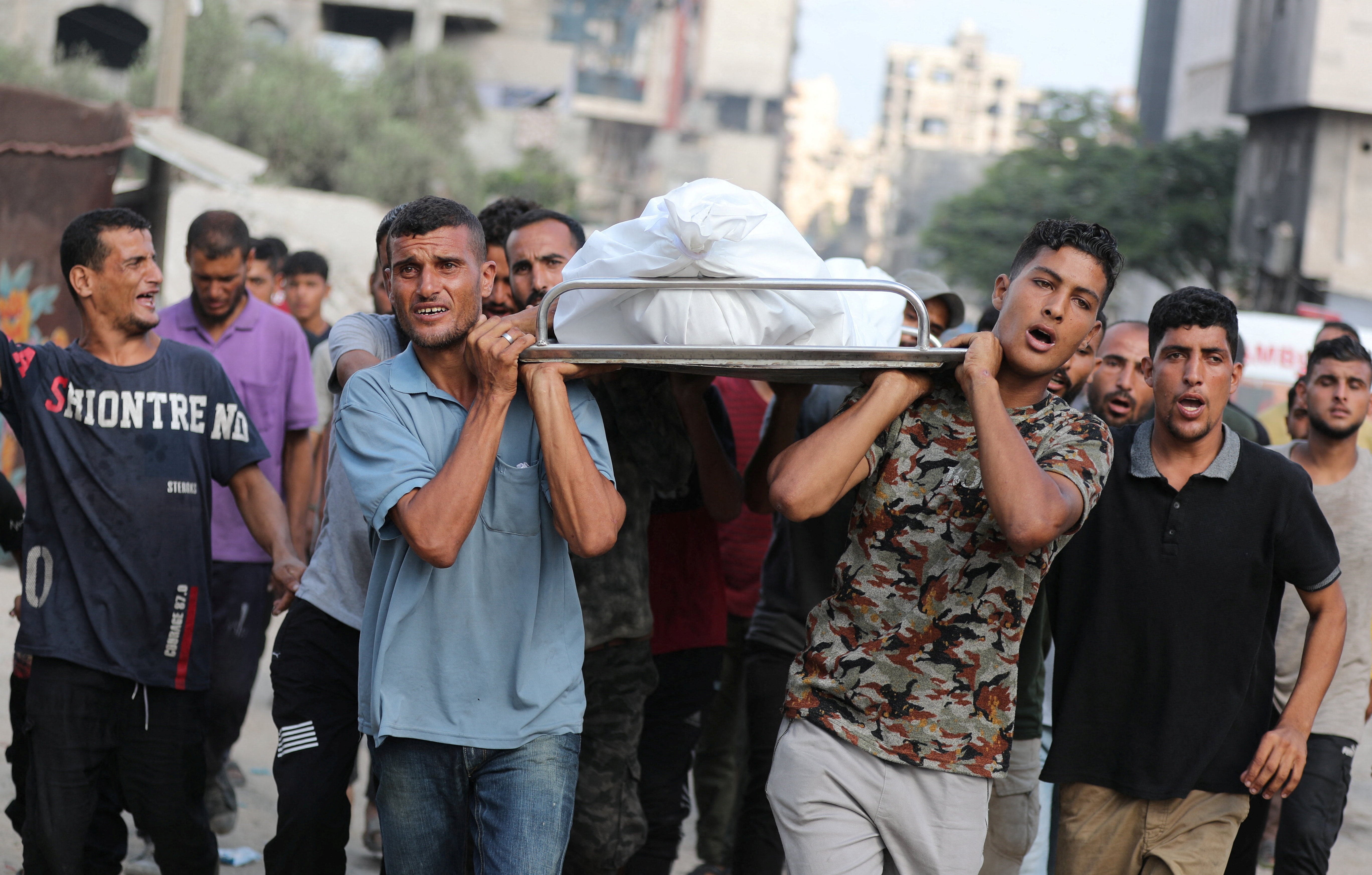 Mourners carry a body during the funeral of Palestinians killed in strikes, according to medics, at Al-Shifa Hospital in Gaza City