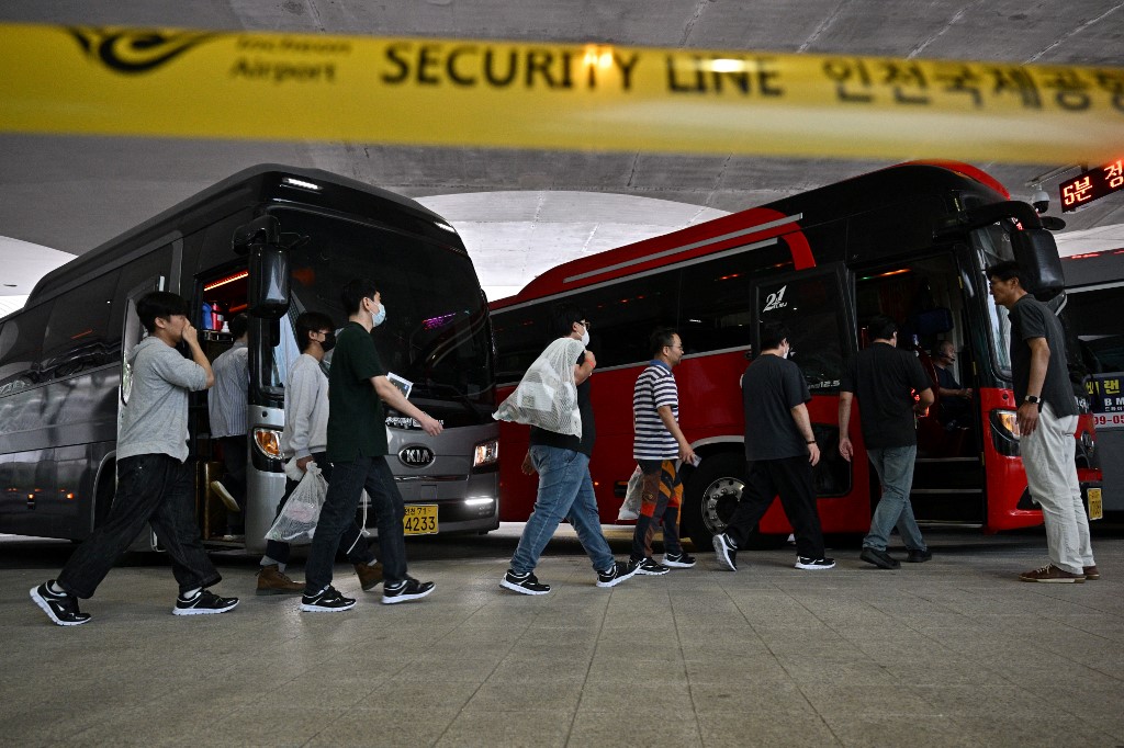 South Korean workers arrive at the airport.