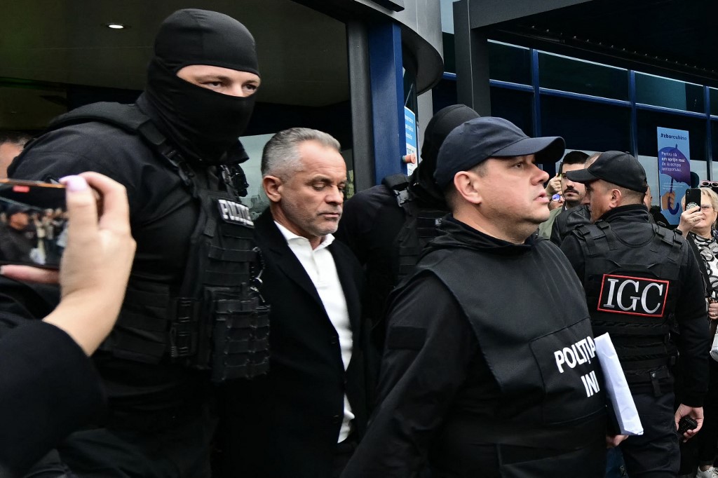 Moldovan oligarch Vladimir Plahotniuc (C), accused of acting of behalf of Russia, exits Chisinau International Airport under police escort, on September 25, 2025, after his extradition from Greece following his arrest earlier in July. [Daniel Mihailescu/AFP]