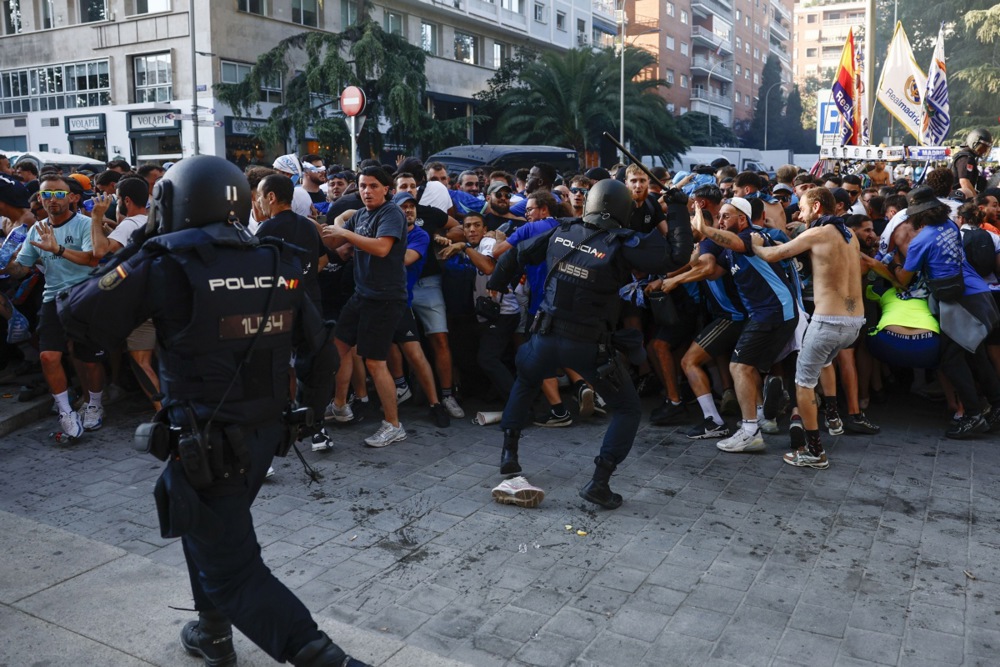 Members of the Spanish national police clash with supporters of Olympique de Marseille near the Santiago Bernabeu stadium ahead of the UEFA Champions League soccer match between Real Madrid and Olympique de Marseille in Madrid