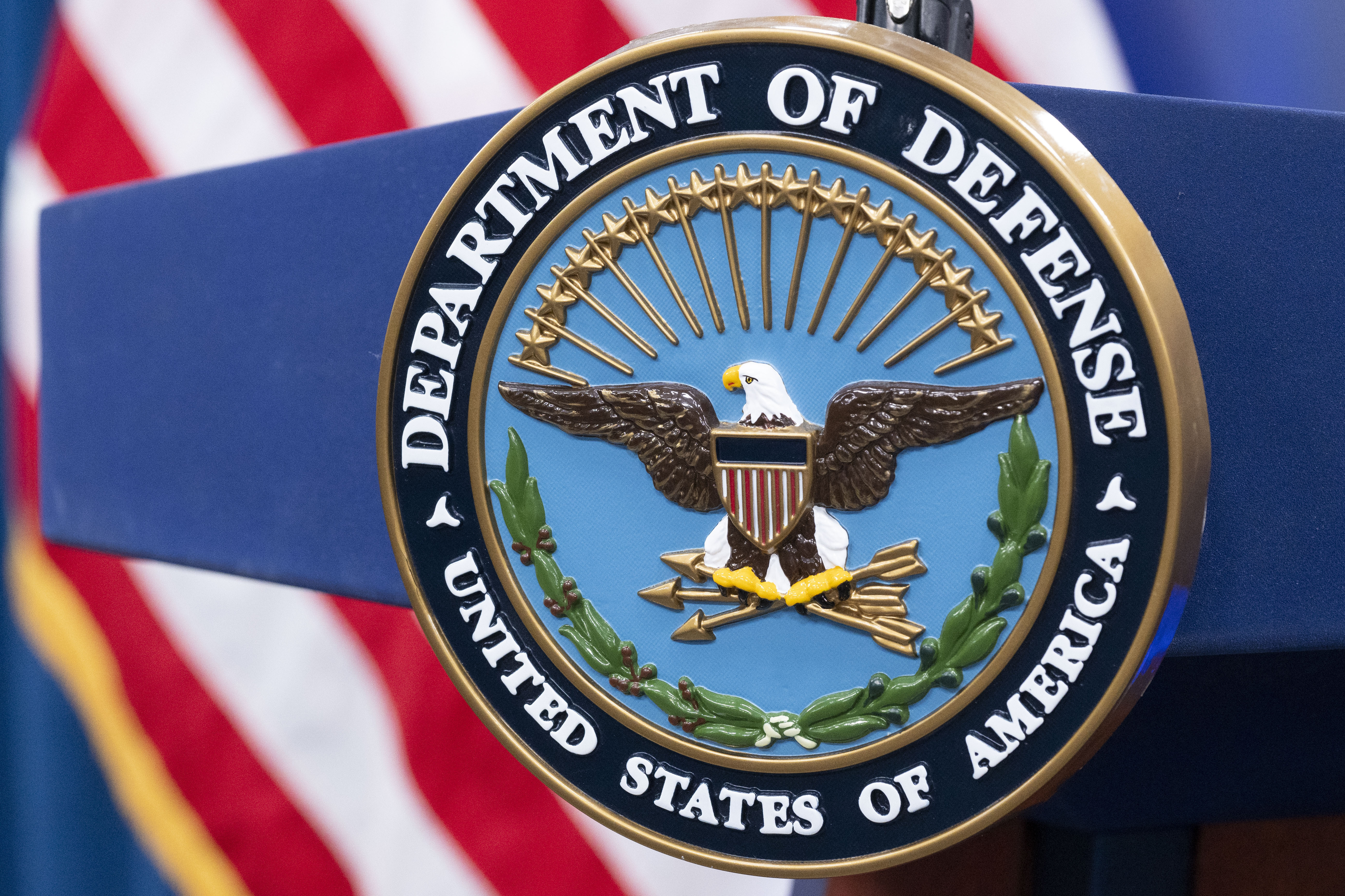 The Department of Defense seal is seen on a podium.