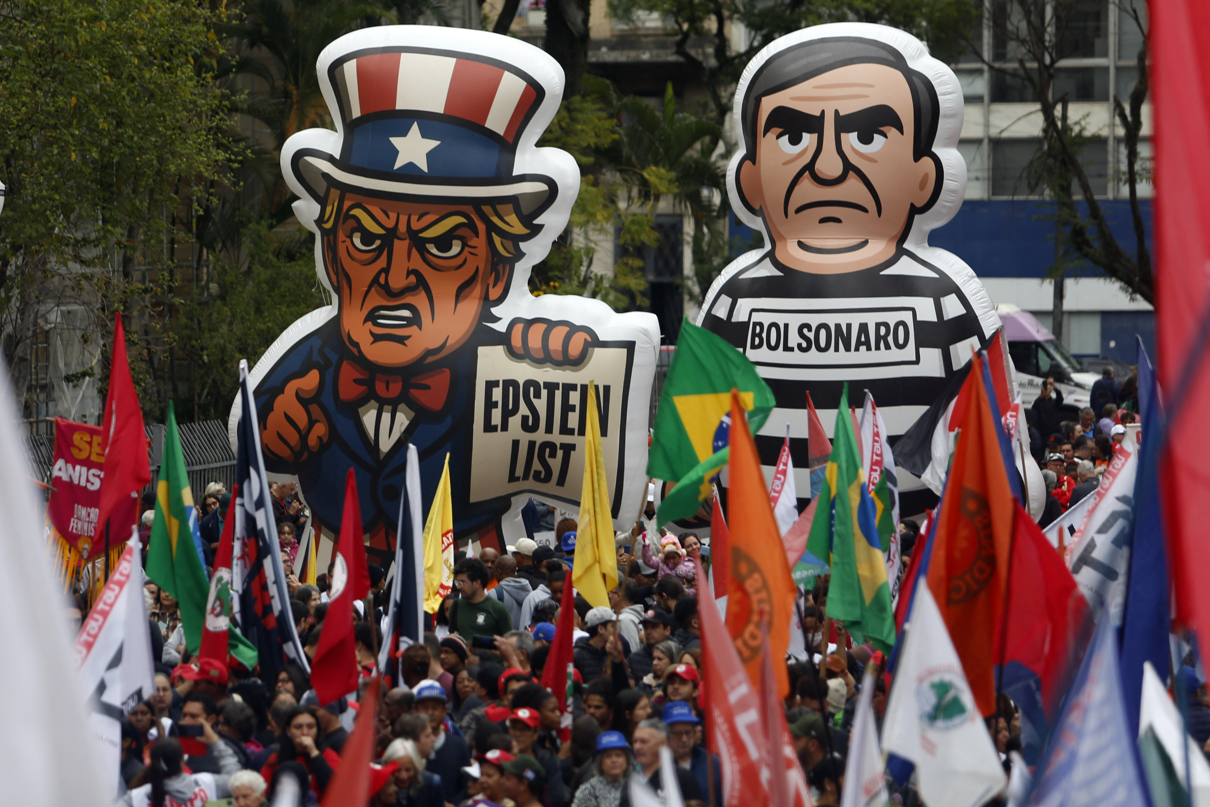 Protesters hold huge signs against former President Jair Bolsonaro and US President Donald Trump.