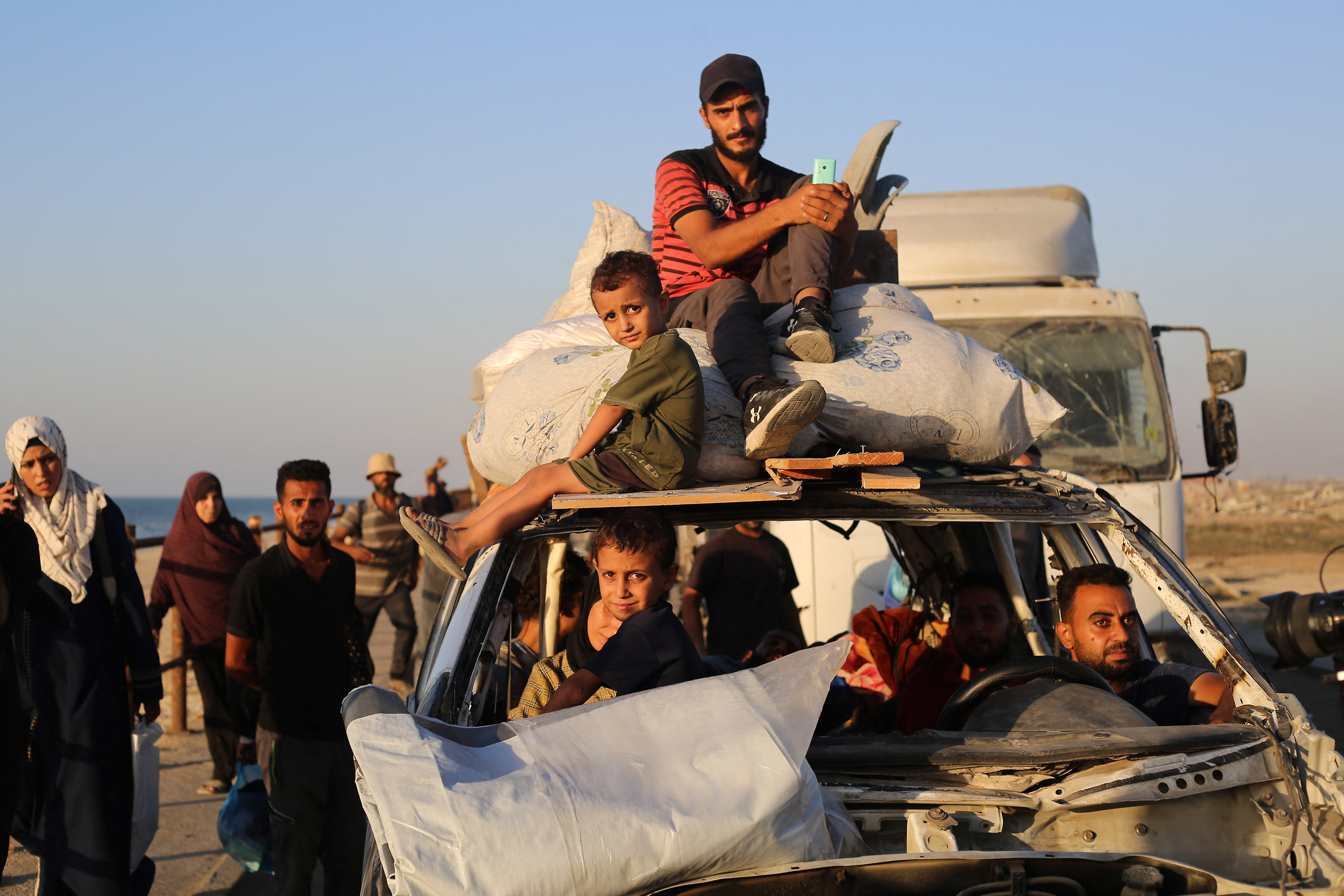 Displaced Palestinians move with their belongings southwards on a road in the Nuseirat refugee camp area in the central Gaza Strip on September 23, 2025, as Israel presses its ground offensive to capture Gaza City amidst the war against Hamas.