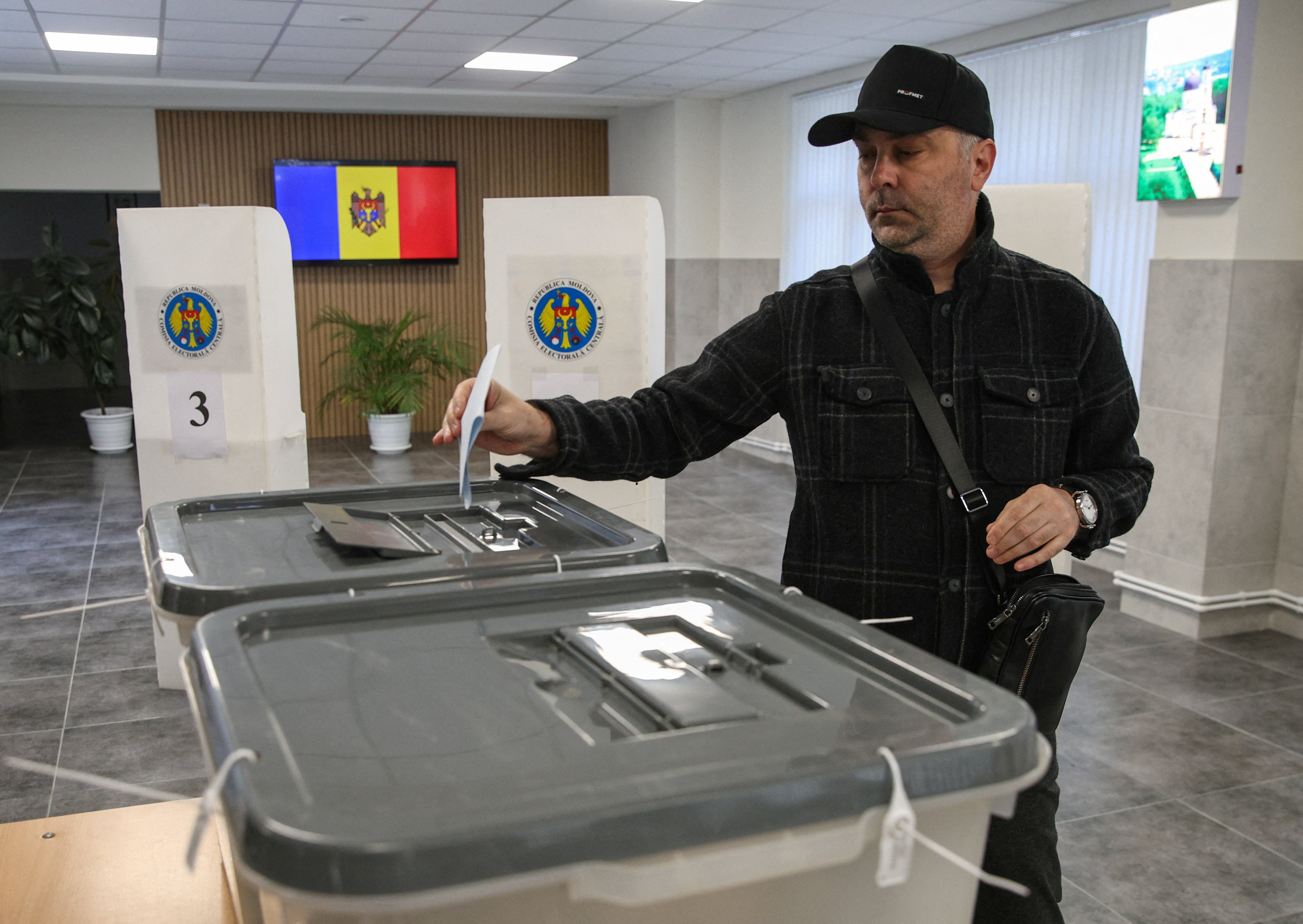 A voter casts his ballot at a polling station during Moldova's parliamentary elections in Chisinau