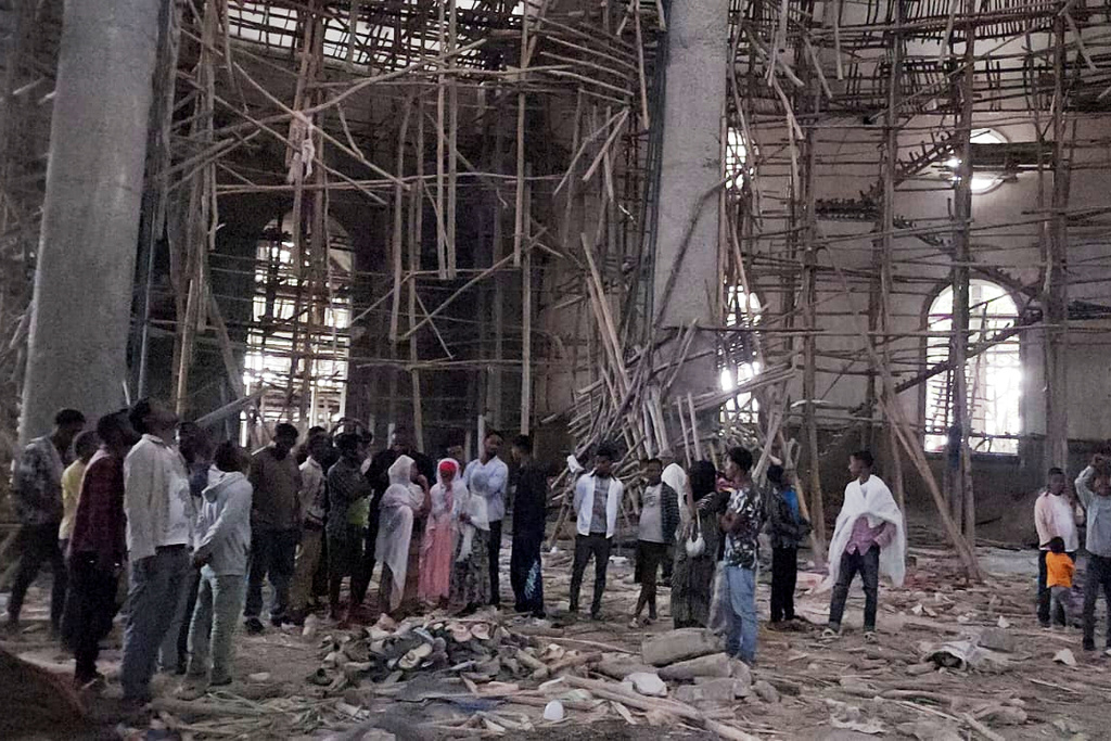 Worshippers stand inside the Menjar Shenkora Arerti Mariam Church under construction that collapsed