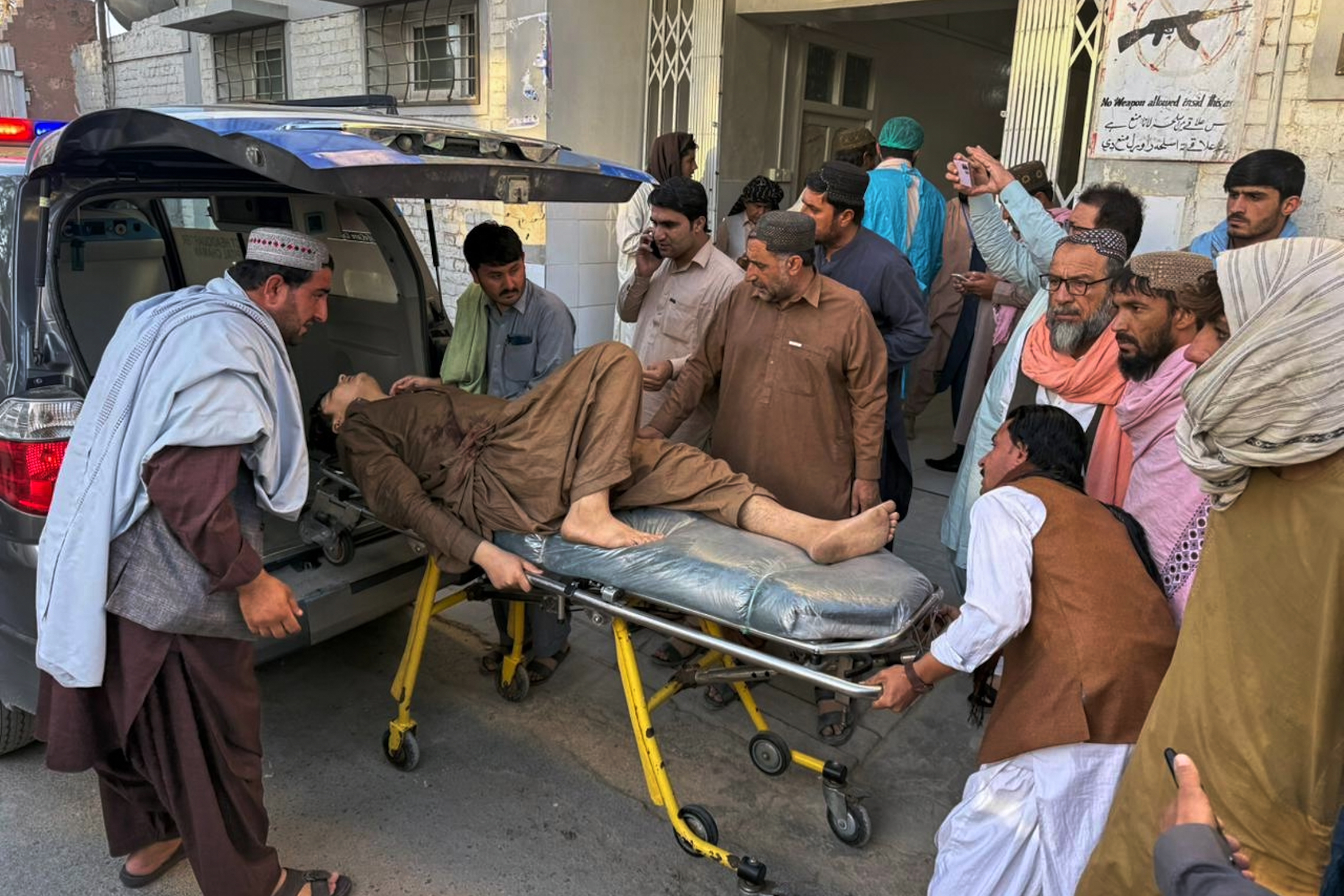 People bring an injured man for medical treatment at a hospital.