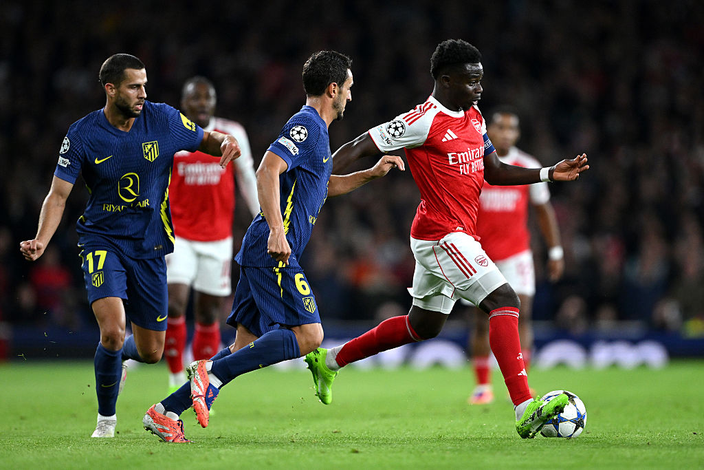 Bukayo Saka of Arsenal runs with the ball whilst under pressure from Koke of Atletico de Madrid during the UEFA Champions League