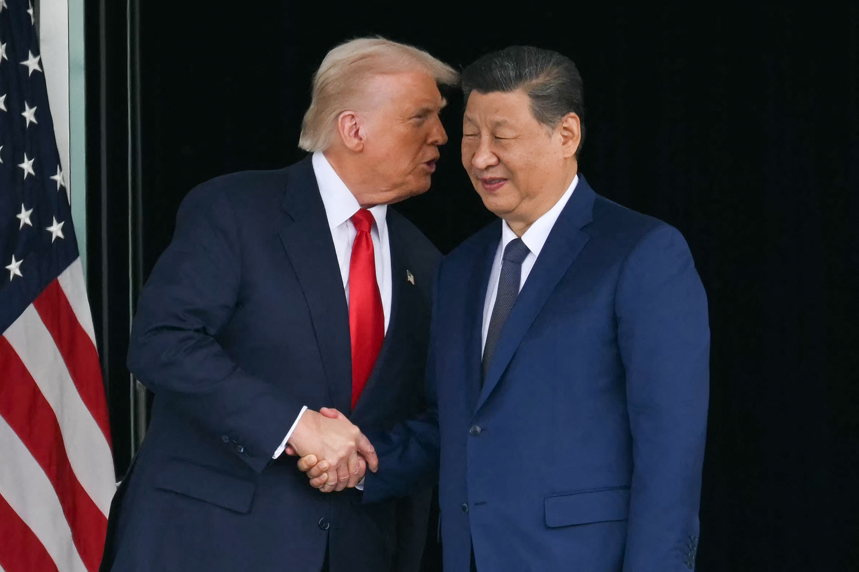 TOPSHOT - US President Donald Trump (L) and China's President Xi Jinping shake hands as they leave after their talks at the Gimhae Air Base, located next to the Gimhae International Airport in Busan on October 30, 2025.