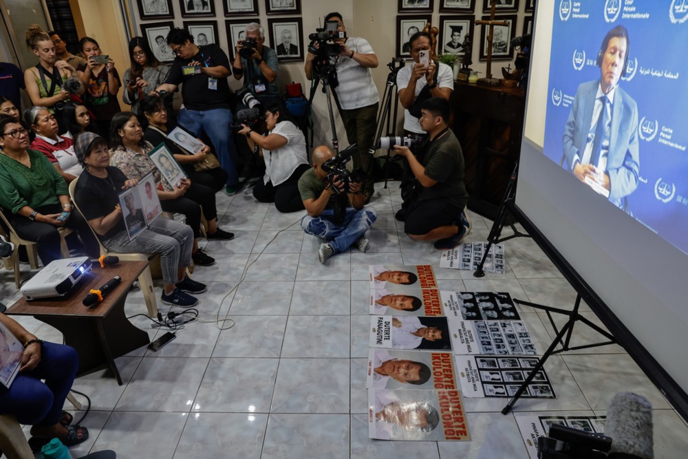 Members of human rights advocacy groups and relatives of victims of alleged extrajudicial killings gather for a live viewing of an ICC hearing on former President Rodrigo Duterte