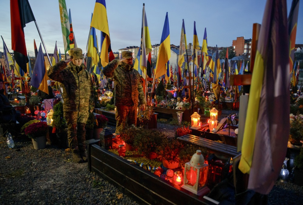 epa12495757 Soldiers salute as they visit the graves of Ukrainian soldiers killed in the armed conflict with Russia at the Lychakiv Cemetery in Lviv, Western Ukraine, 31 October 2025, as Ukrainian Greek Catholics mark All Saints' Day and Day of the Dead amid the ongoing Russian invasion. EPA/MYKOLA TYS