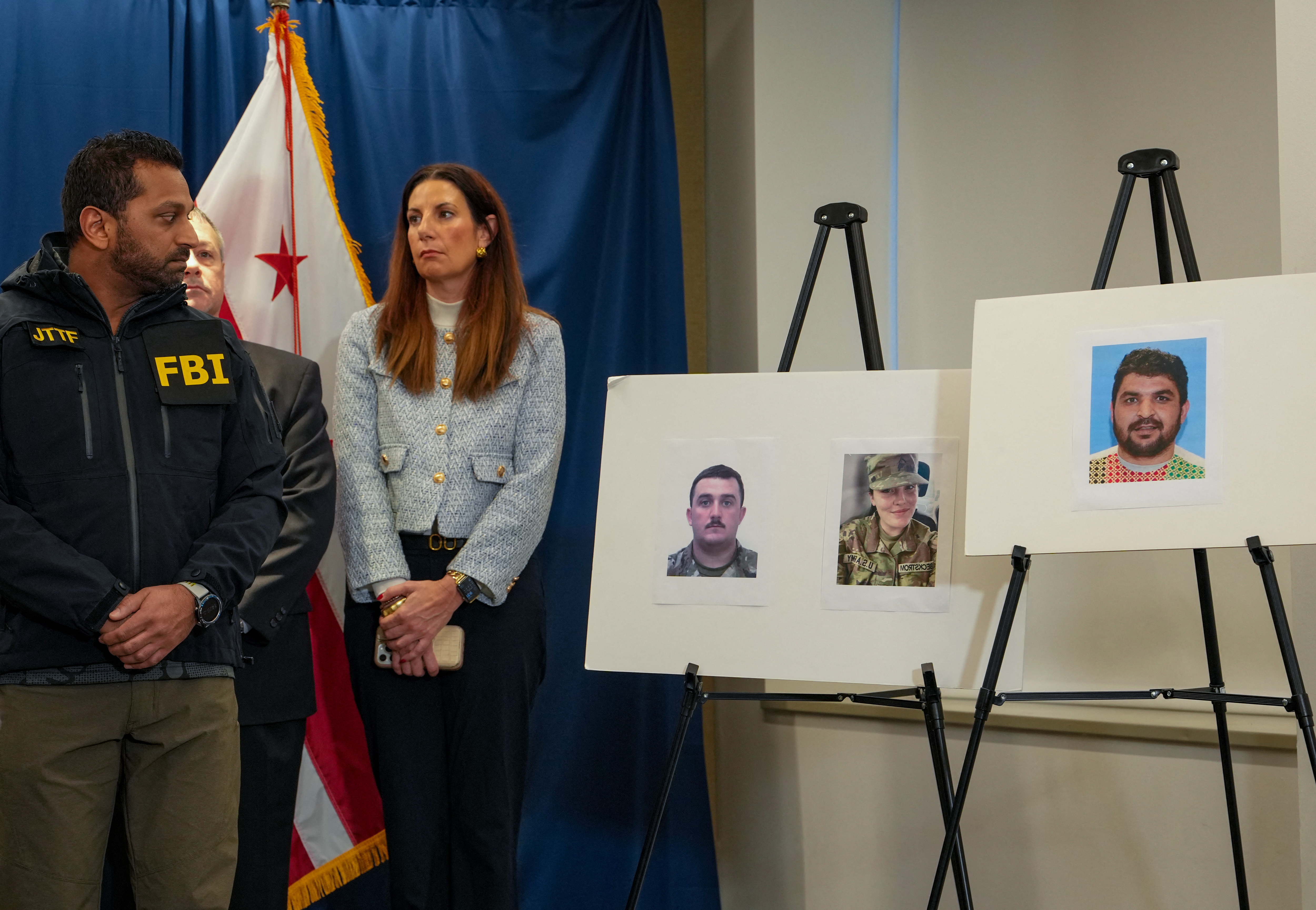 FBI Director Kash Patel (L) looks at photos of the two West Virginia National Guard soldiers shot in Washington, D.C., along with the suspect in the shooting