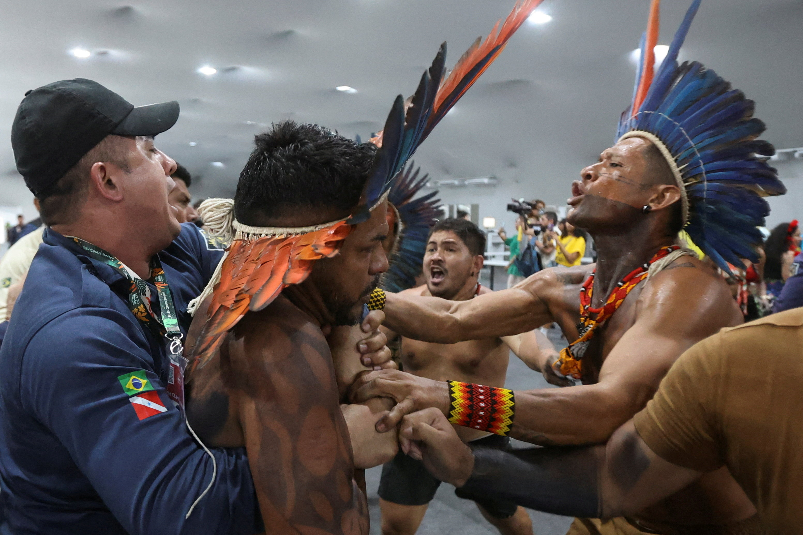 An Indigenous demonstrator is held by a staff member as protesters force their way into the venue hosting the UN Climate Change Conference (COP30), in Belem, Brazil, November 11, 2025. REUTERS/Anderson Coelho TPX IMAGES OF THE DAY