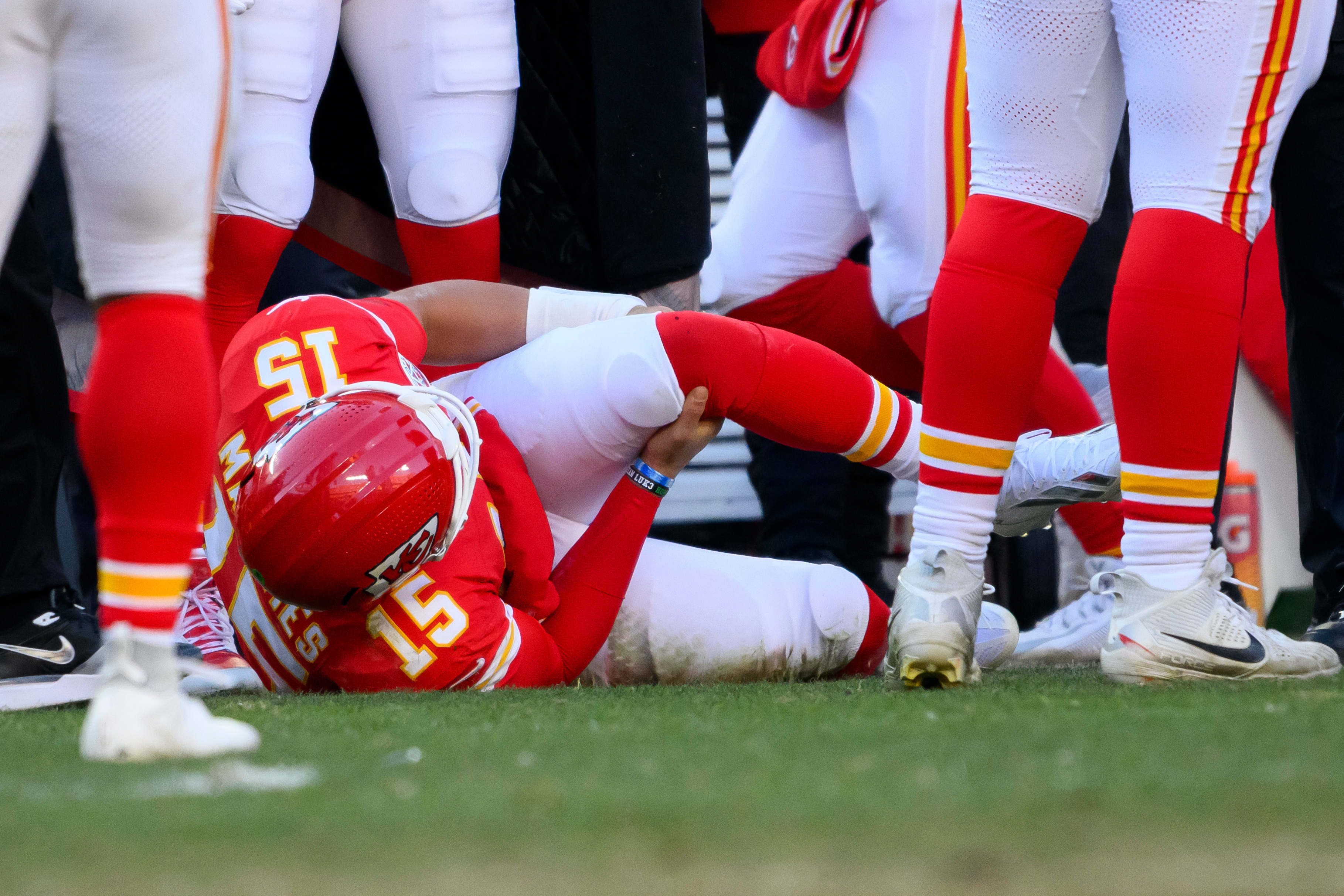 Patrick Mahomes grabs his knee as he lies on the field after an injury.