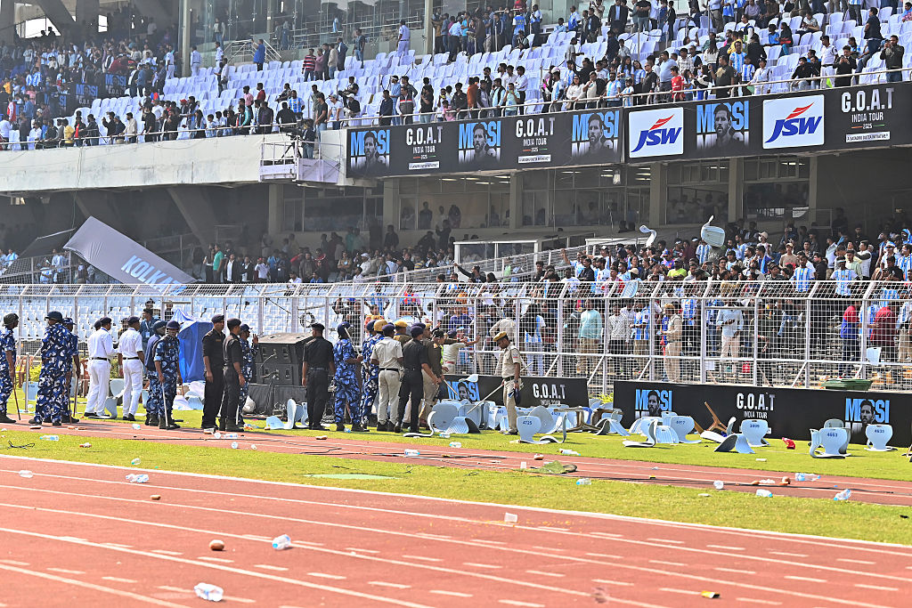 Police officials speak to the spectators as they throw debris on to the field at Vivekananda Yuva Bharati Krirangan (VYBK) during the Lionel Messi G.O.A.T Tour