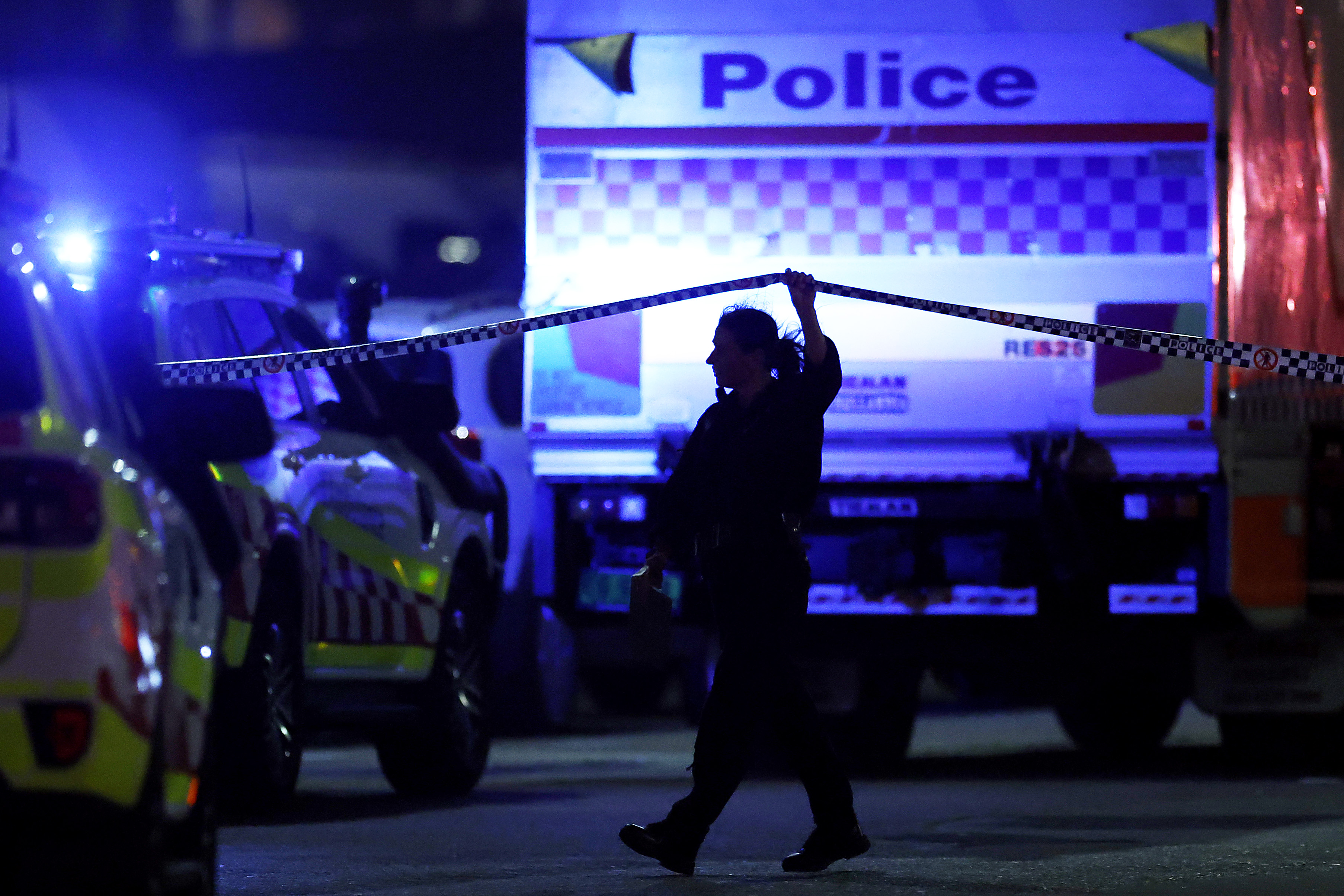 A police officer walks along cordon tapeline
