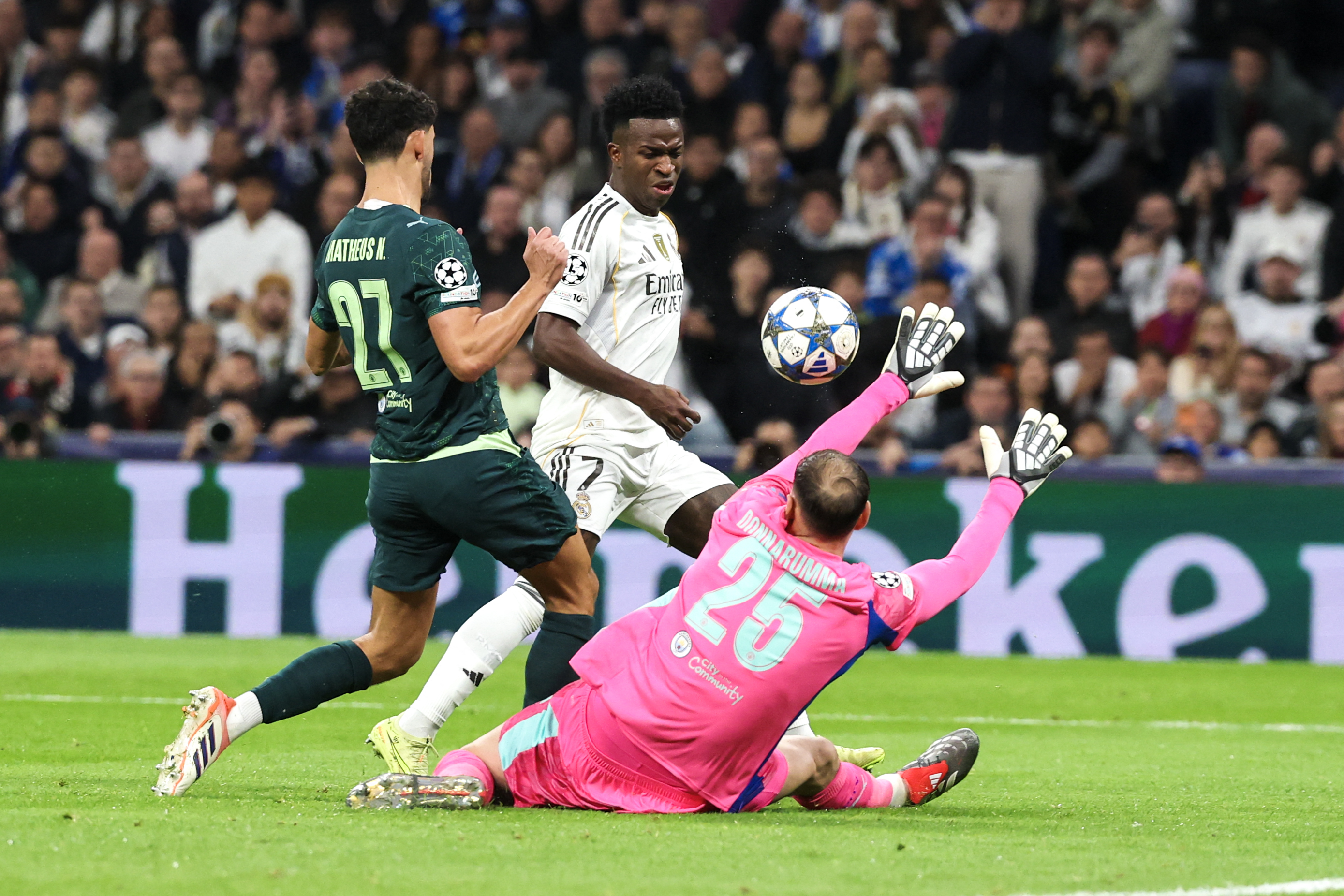 Real Madrid's Brazilian forward #07 Vinicius Junior (C) fails to score past Manchester City's Italian goalkeeper #25 Gianluigi Donnarumma during the UEFA Champions League league phase day 6 football match between Real Madrid CF and Manchester City at Santiago Bernabeu Stadium in Madrid on December 10, 2025.