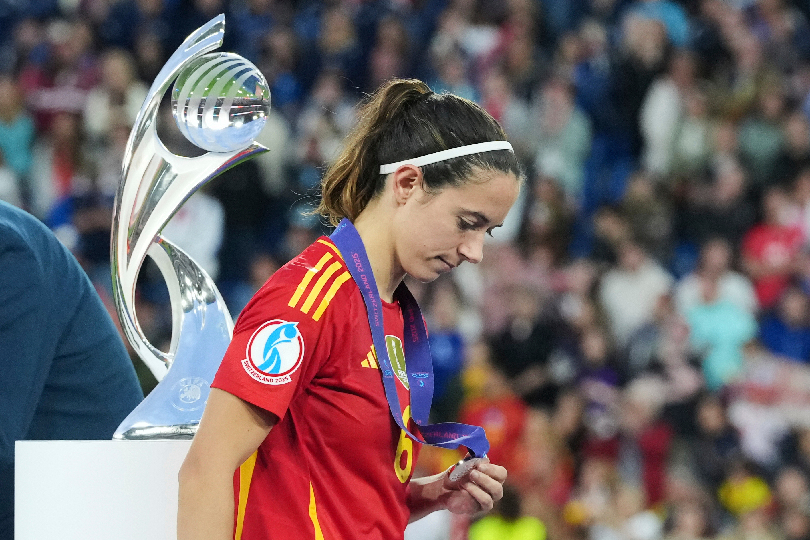 Spain's Aitana Bonmati walks past a trophy with her runners-up medal.